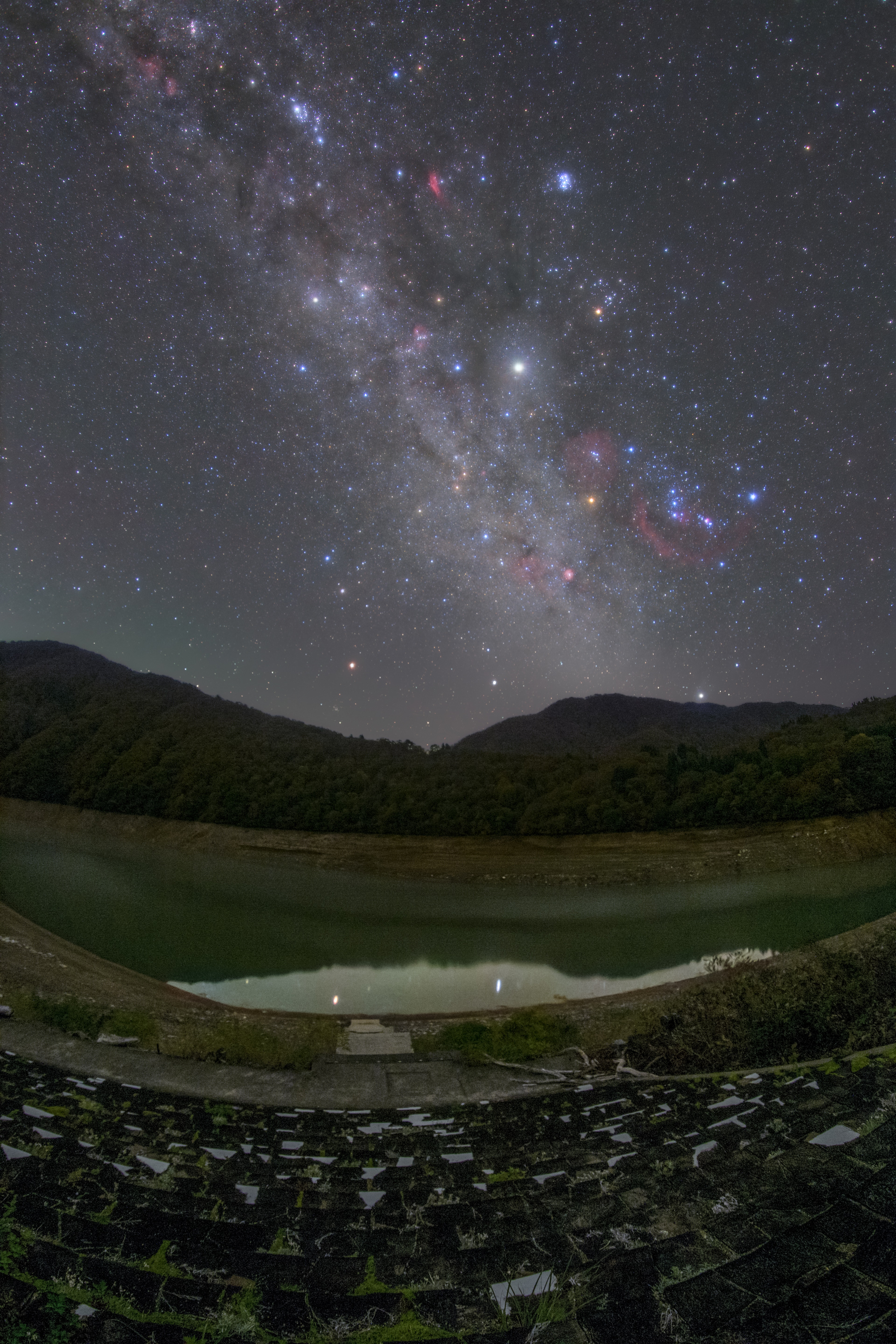 星空と山々が広がる夜景で河川が映る