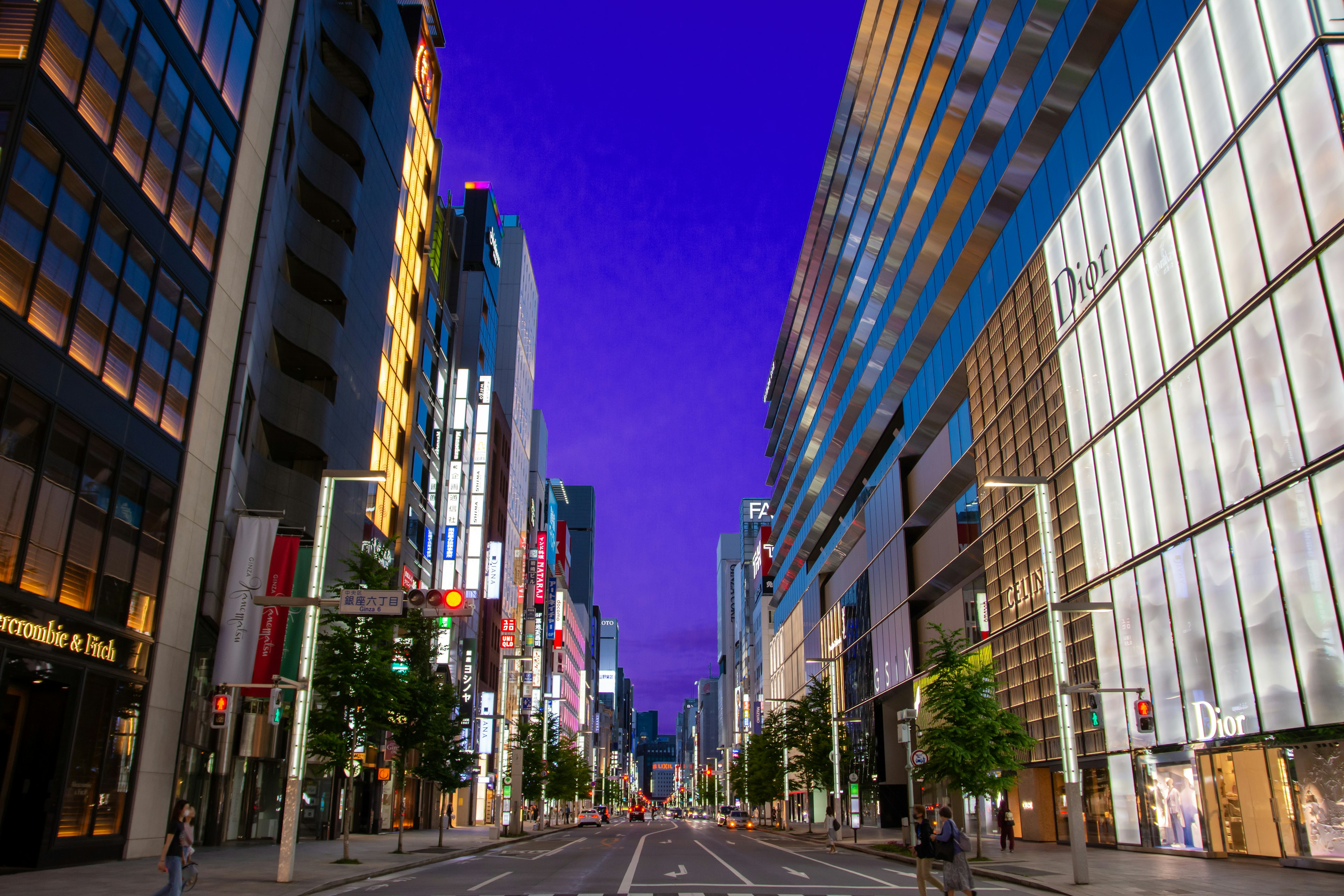 Quiet city street lined with skyscrapers and purple sky