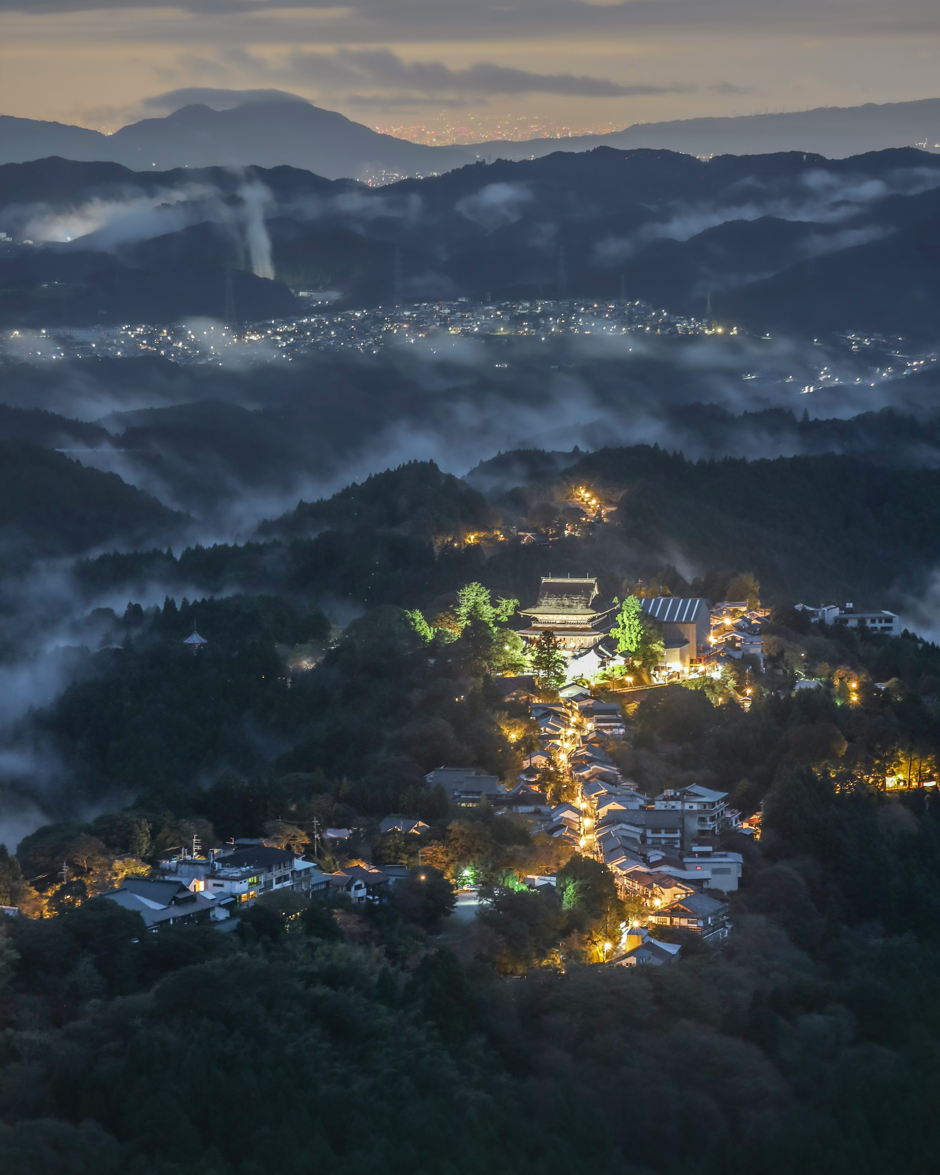 夜の山々と霧に包まれた集落の美しい風景