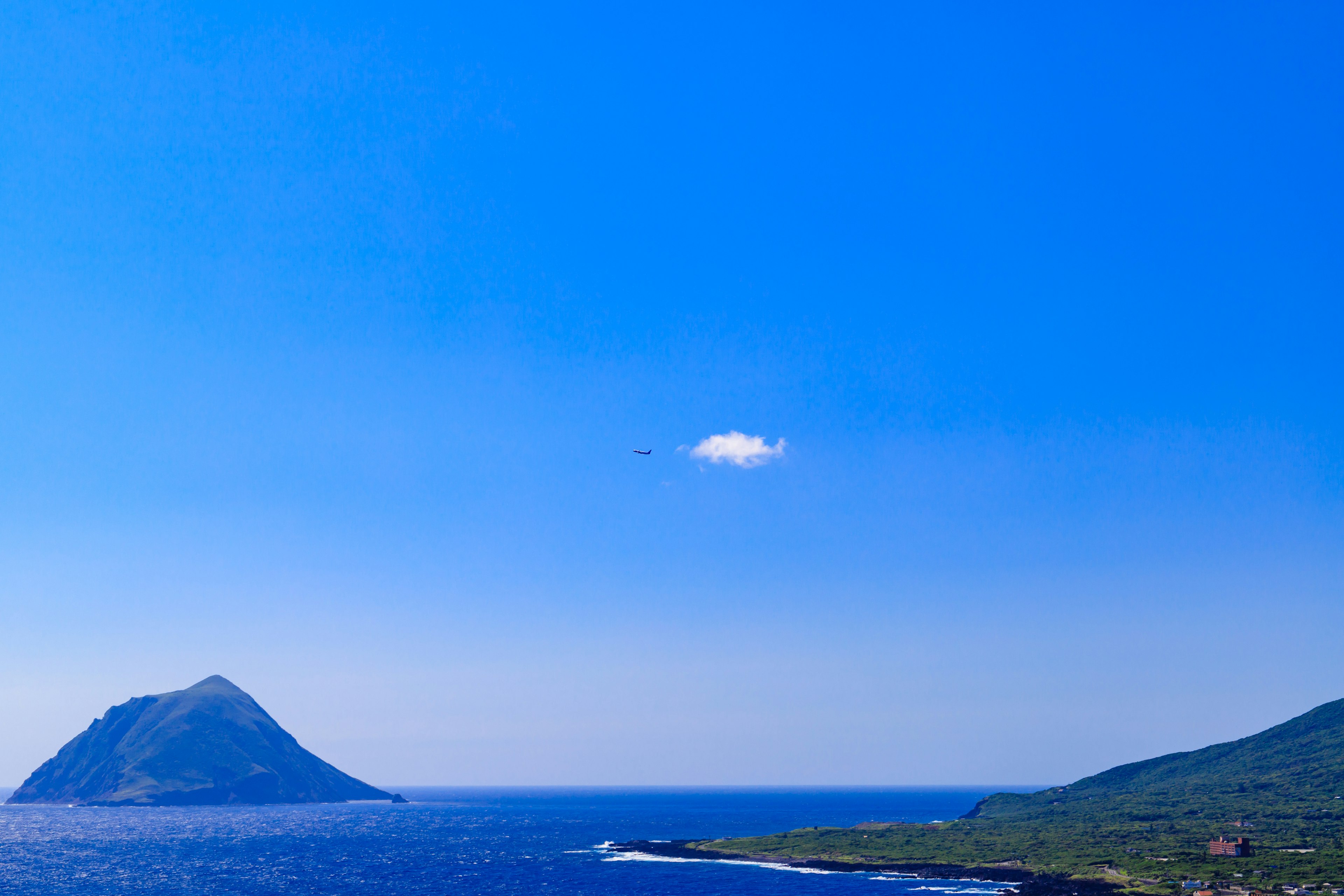 Pemandangan langit biru dan laut jernih dengan awan kecil