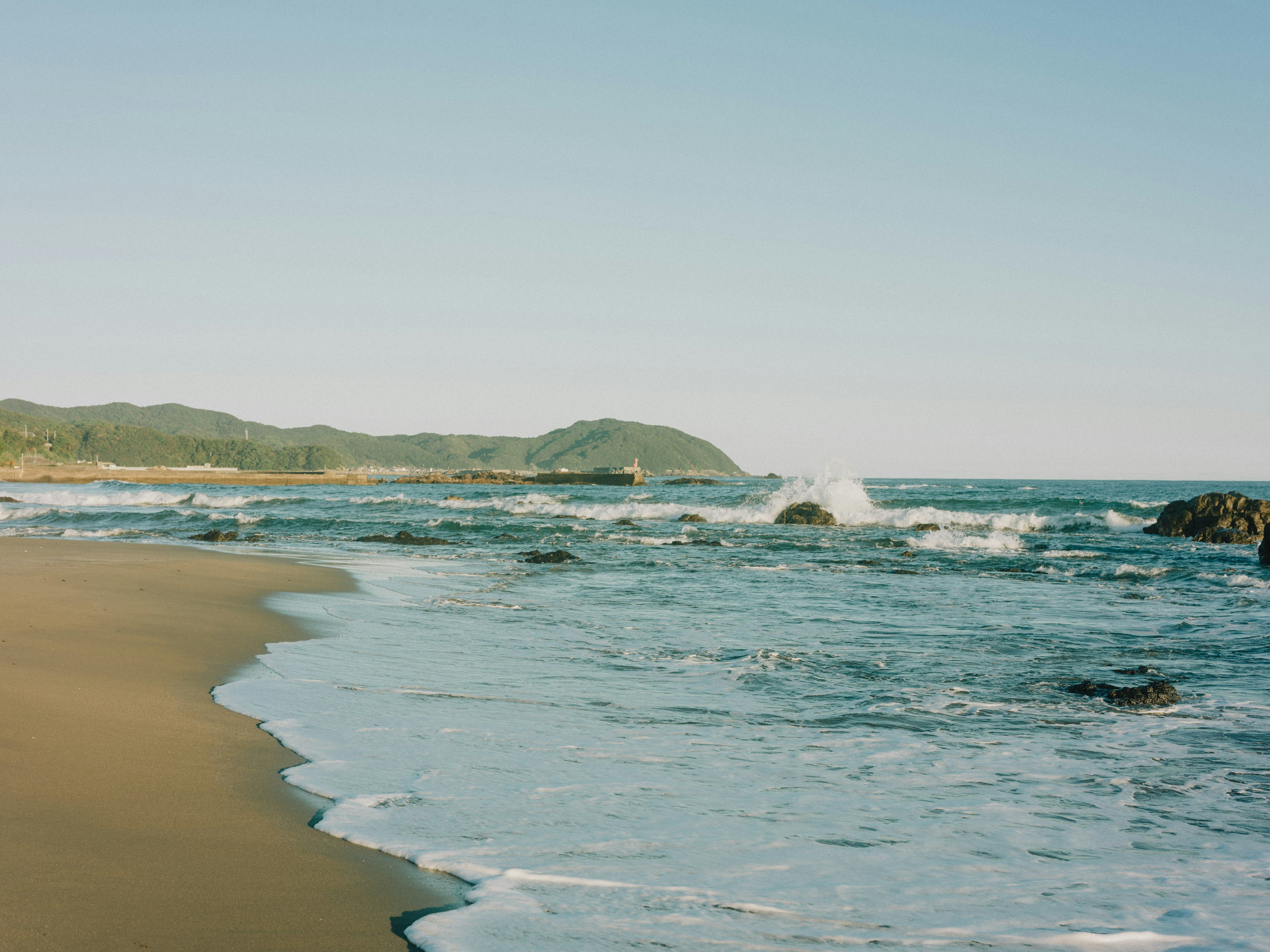 穏やかな海岸線と波が打ち寄せる海の景色