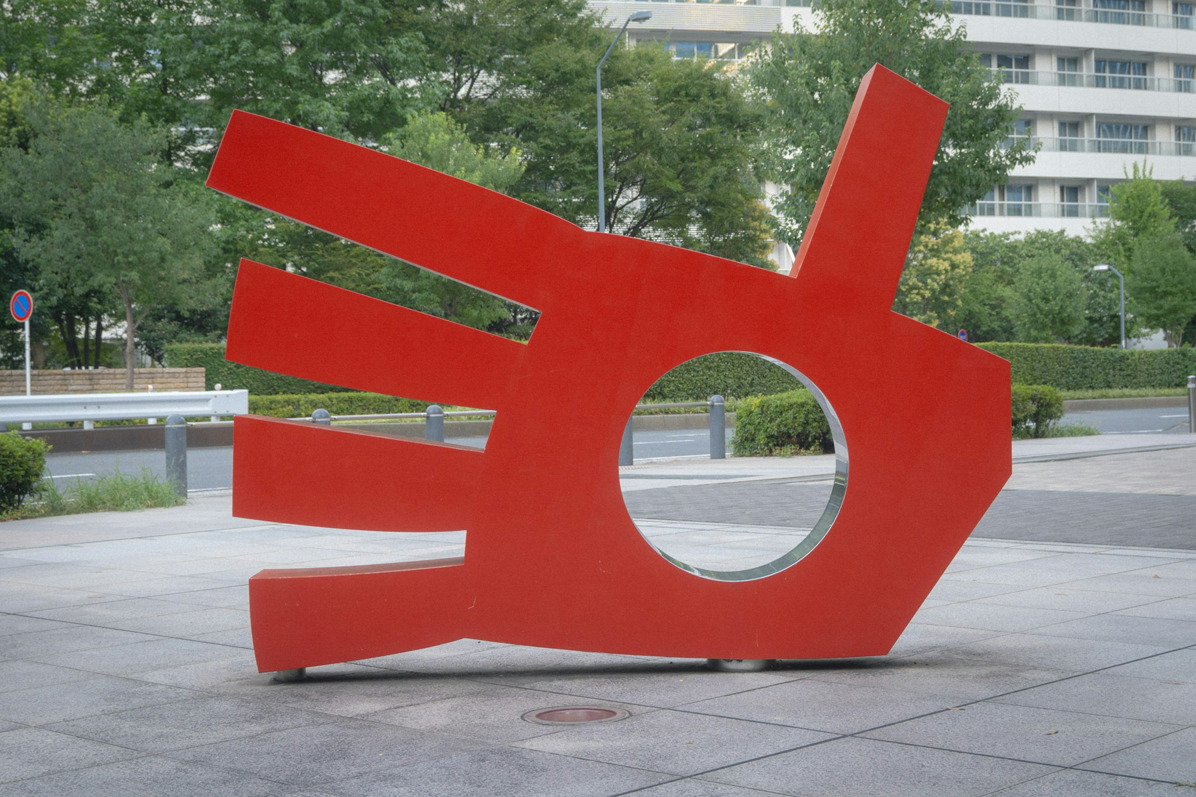 Escultura en forma de mano roja con un agujero circular en el centro