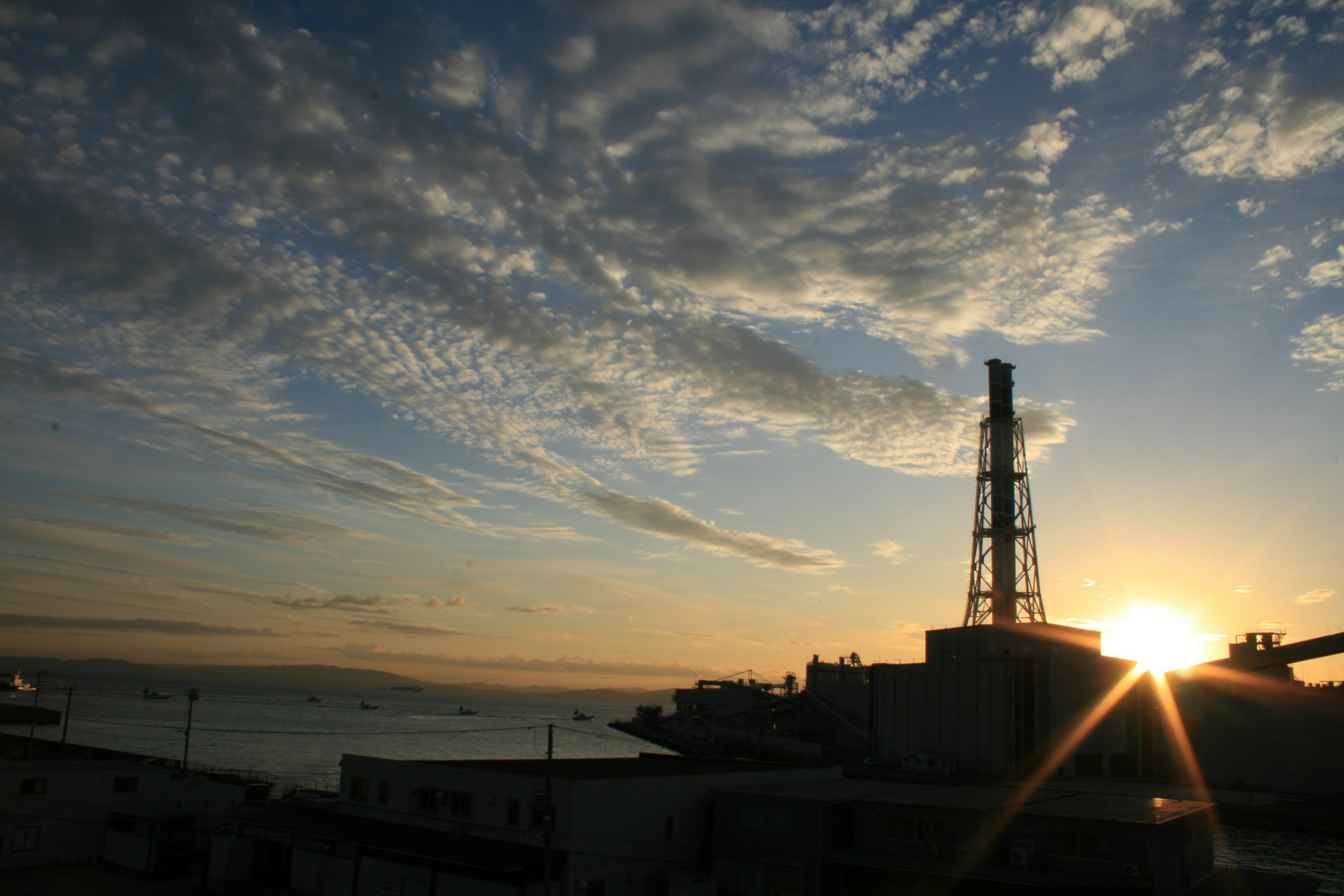 Structure industrielle avec un coucher de soleil et ciel nuageux