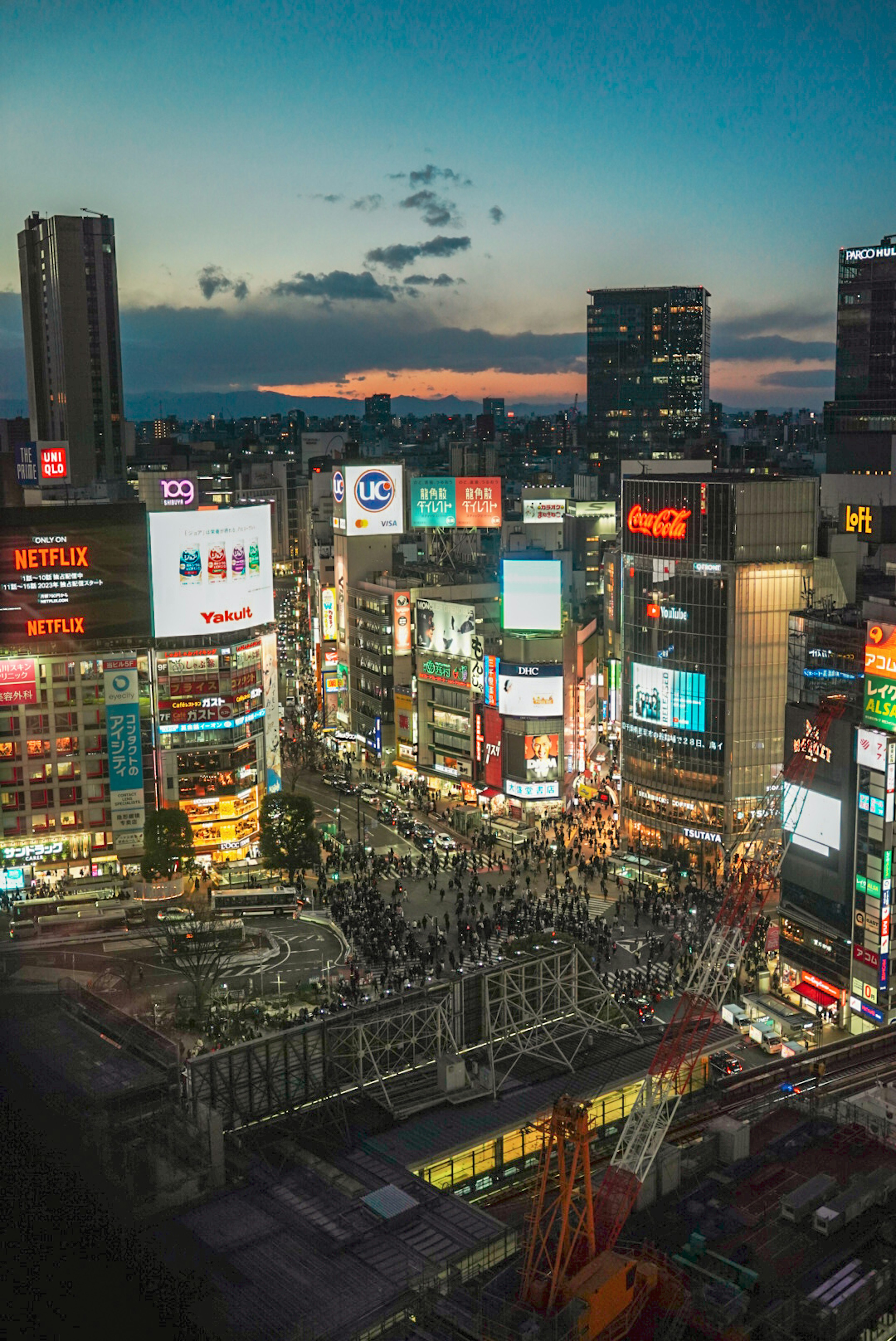 Night view of Shibuya bustling cityscape with busy intersection and bright billboards