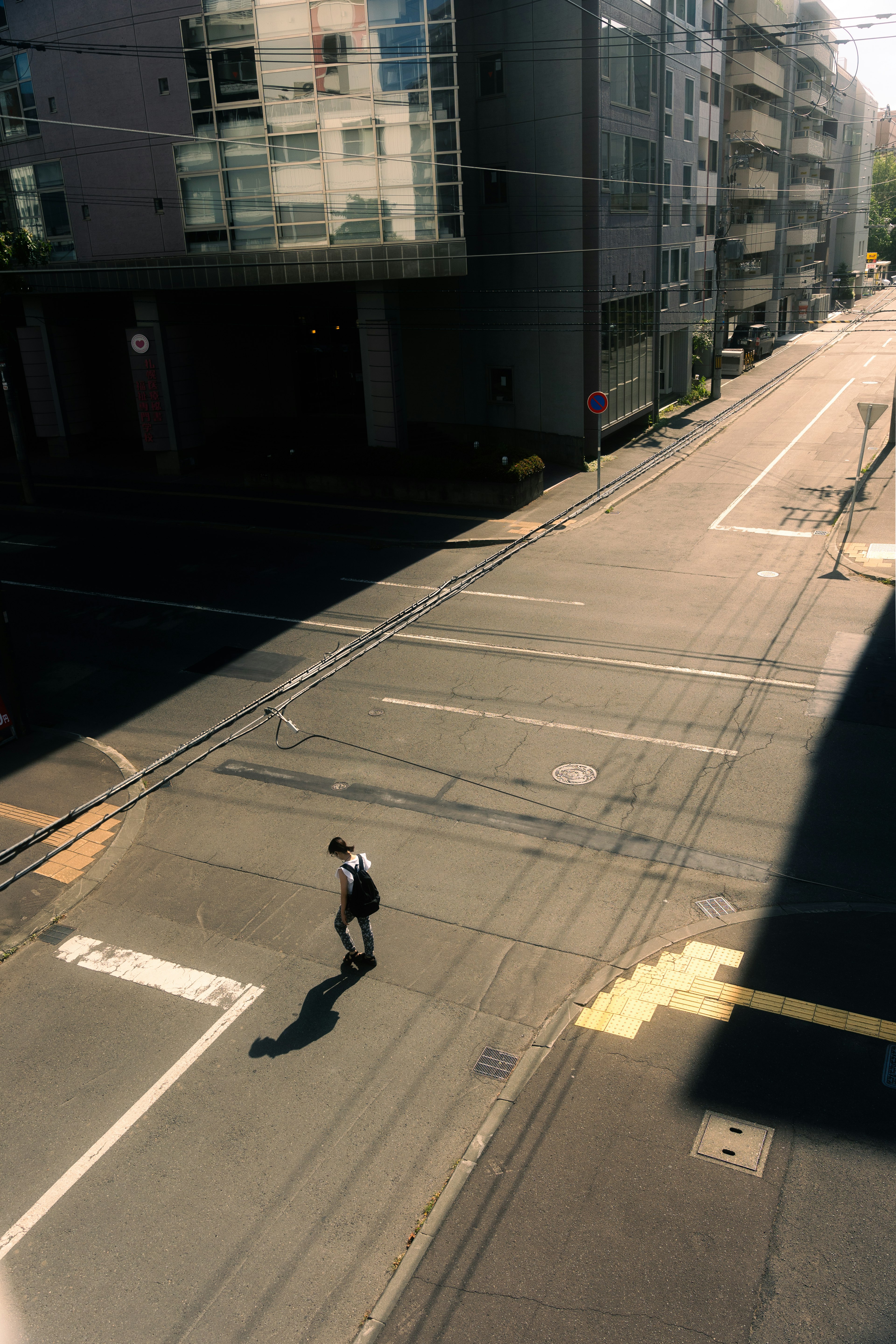 Una persona caminando sola en una intersección urbana tranquila