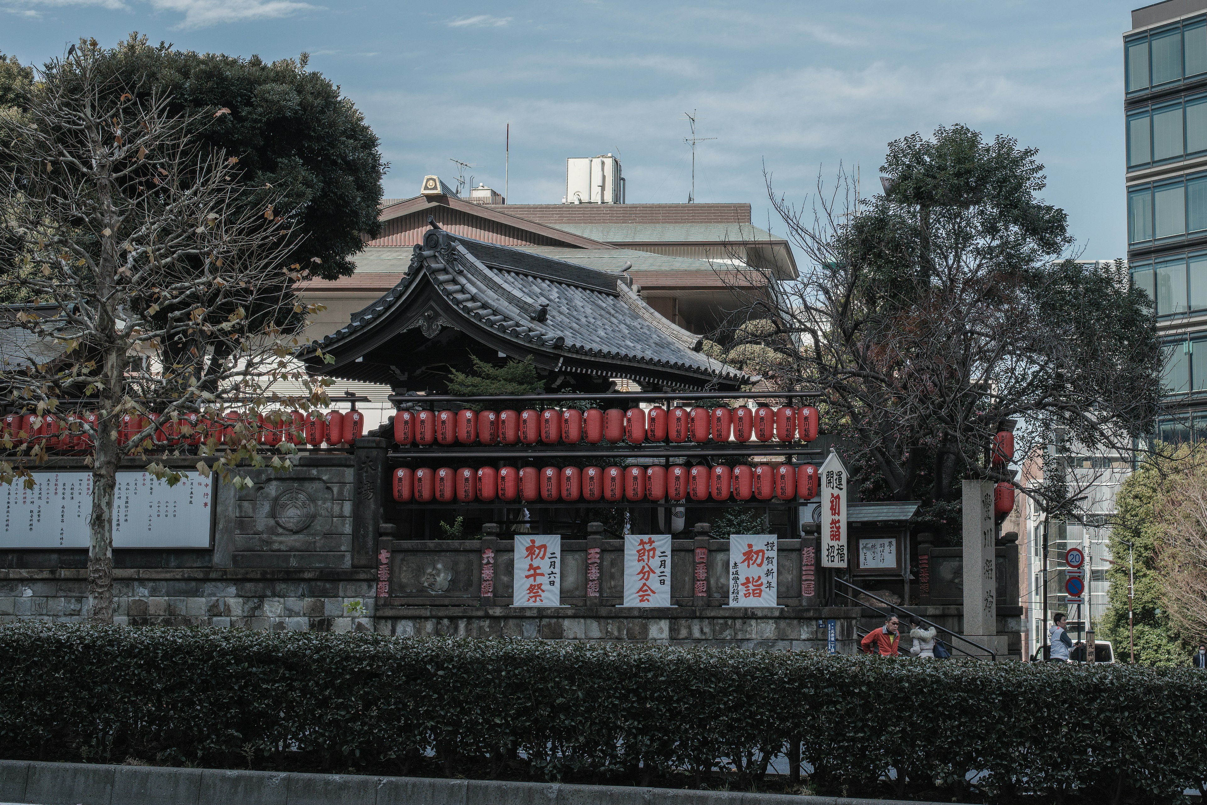 赤い提灯が飾られた伝統的な日本の建物と現代的なビルが並ぶ風景