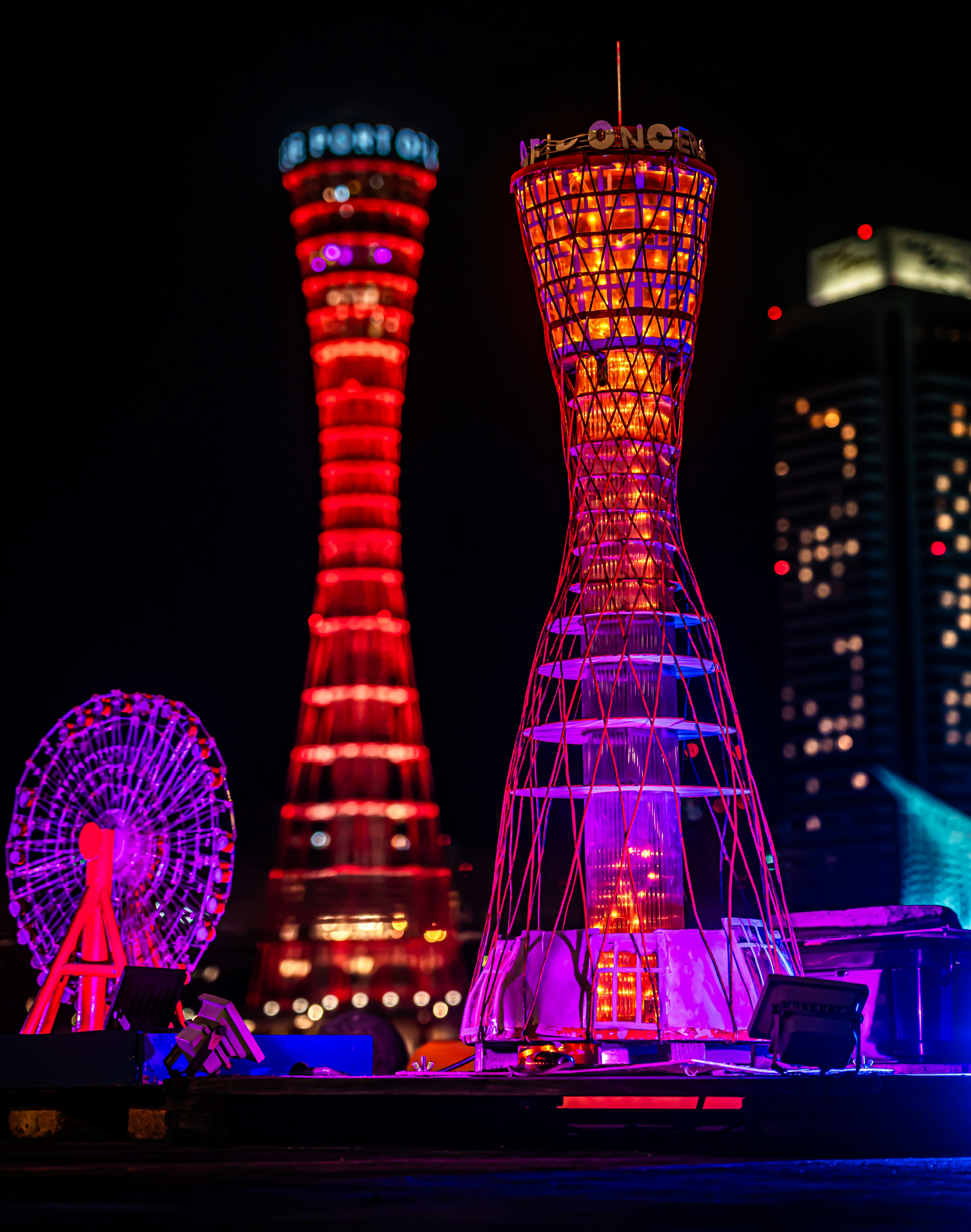 Torri illuminate e ruota panoramica nello skyline notturno di Kobe