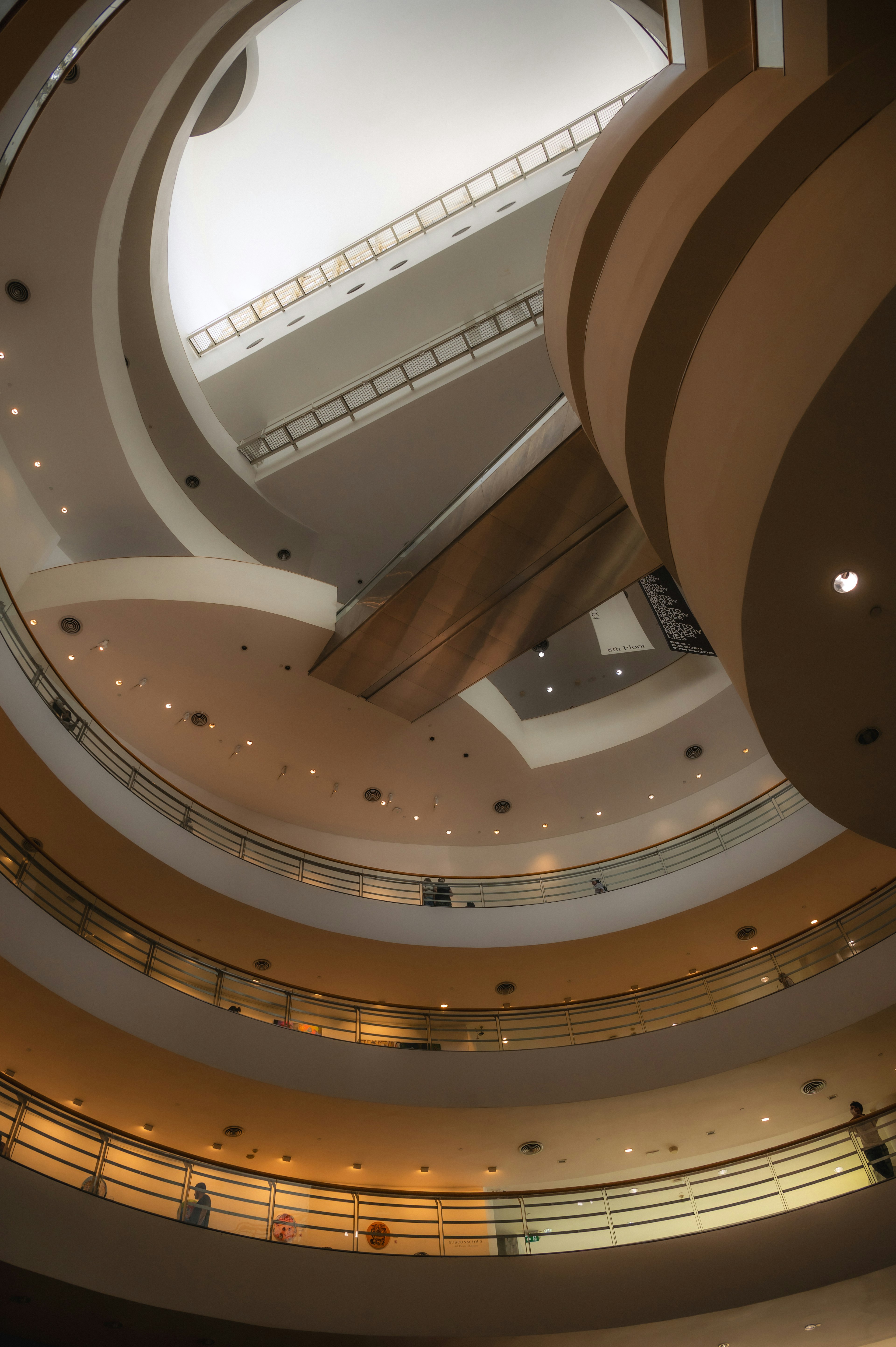 Vista interior de una escalera circular con iluminación brillante en un museo de arte