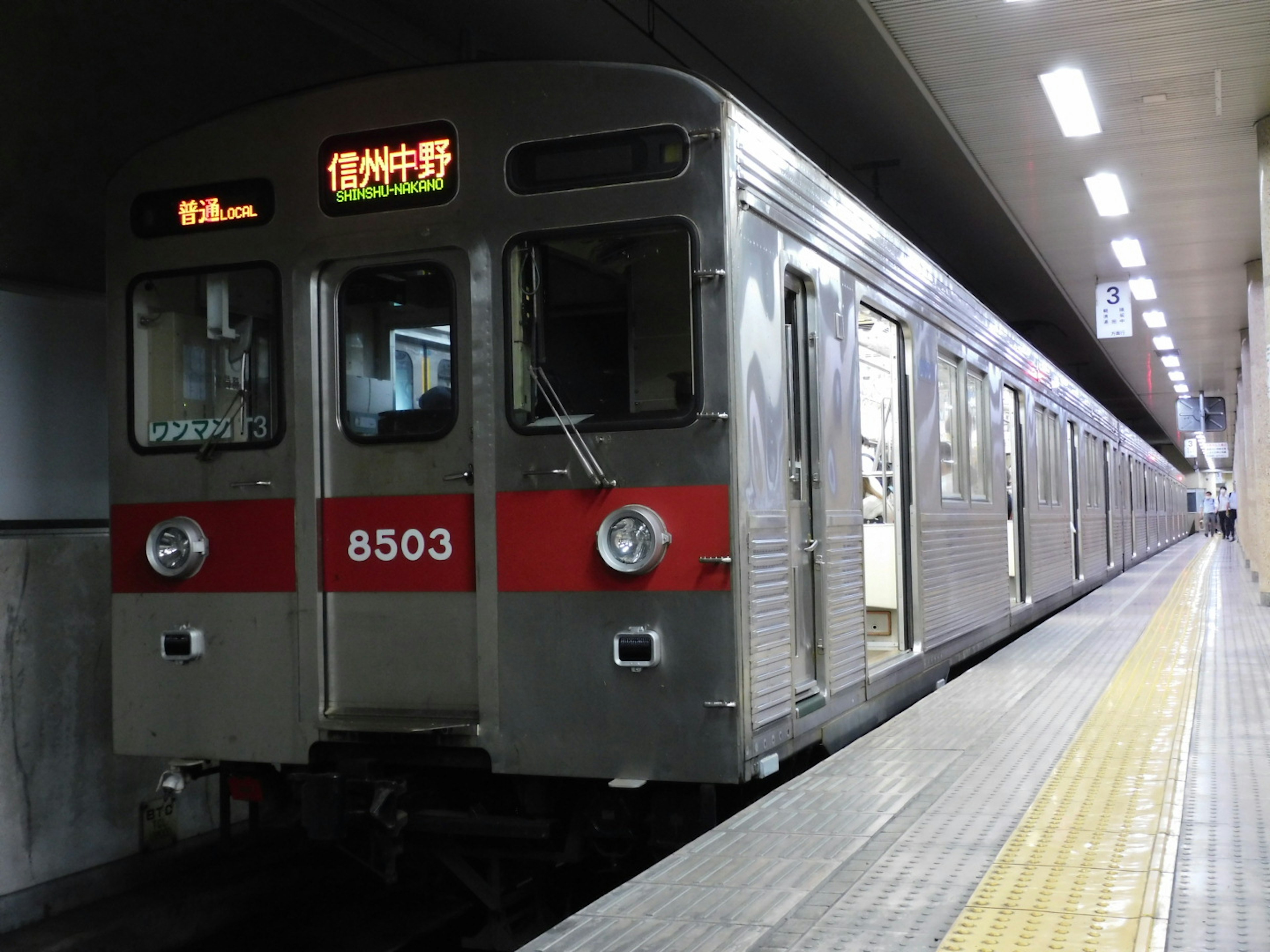 Train de métro argenté à une station