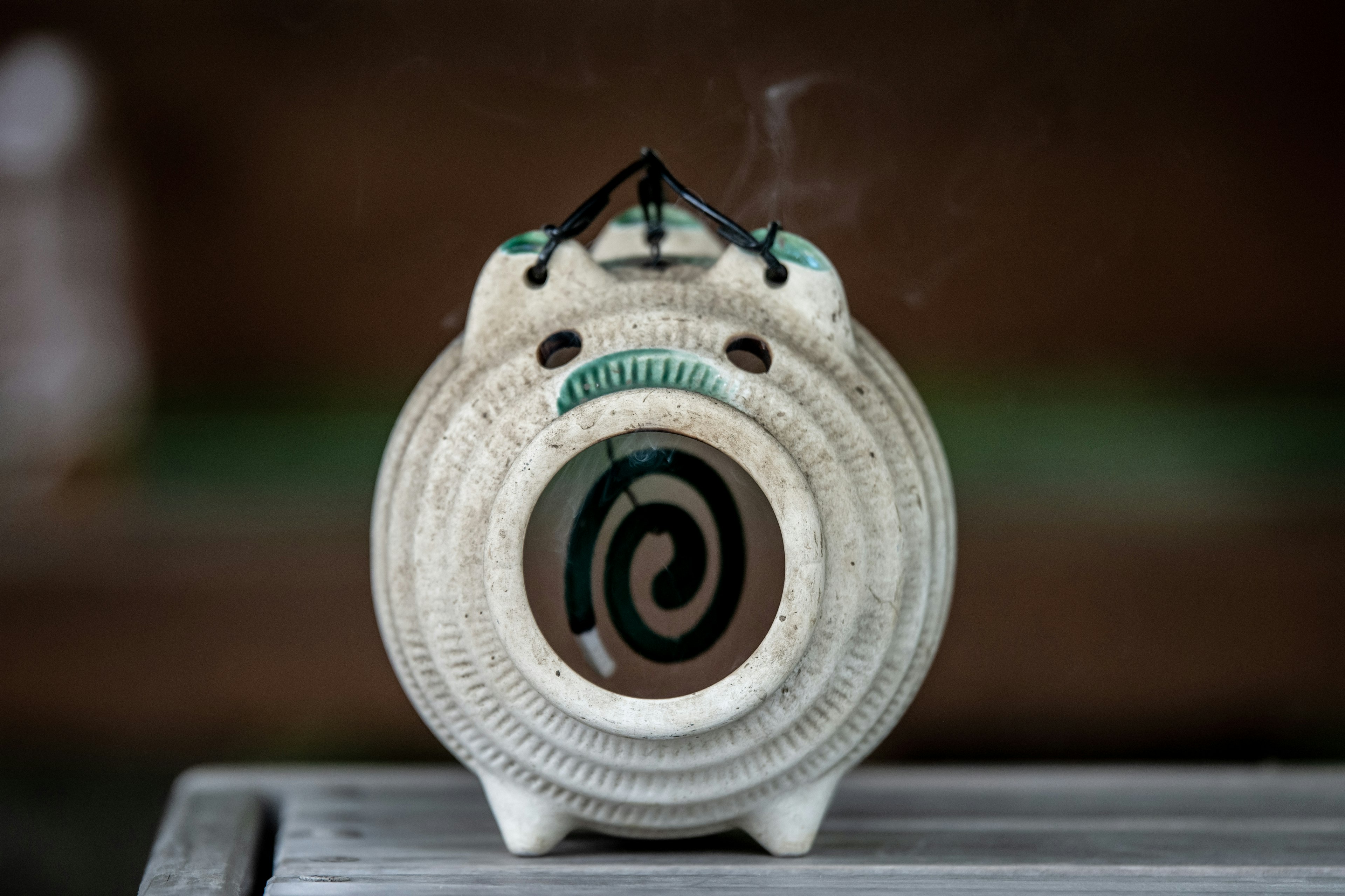 White ceramic incense holder with smoke rising