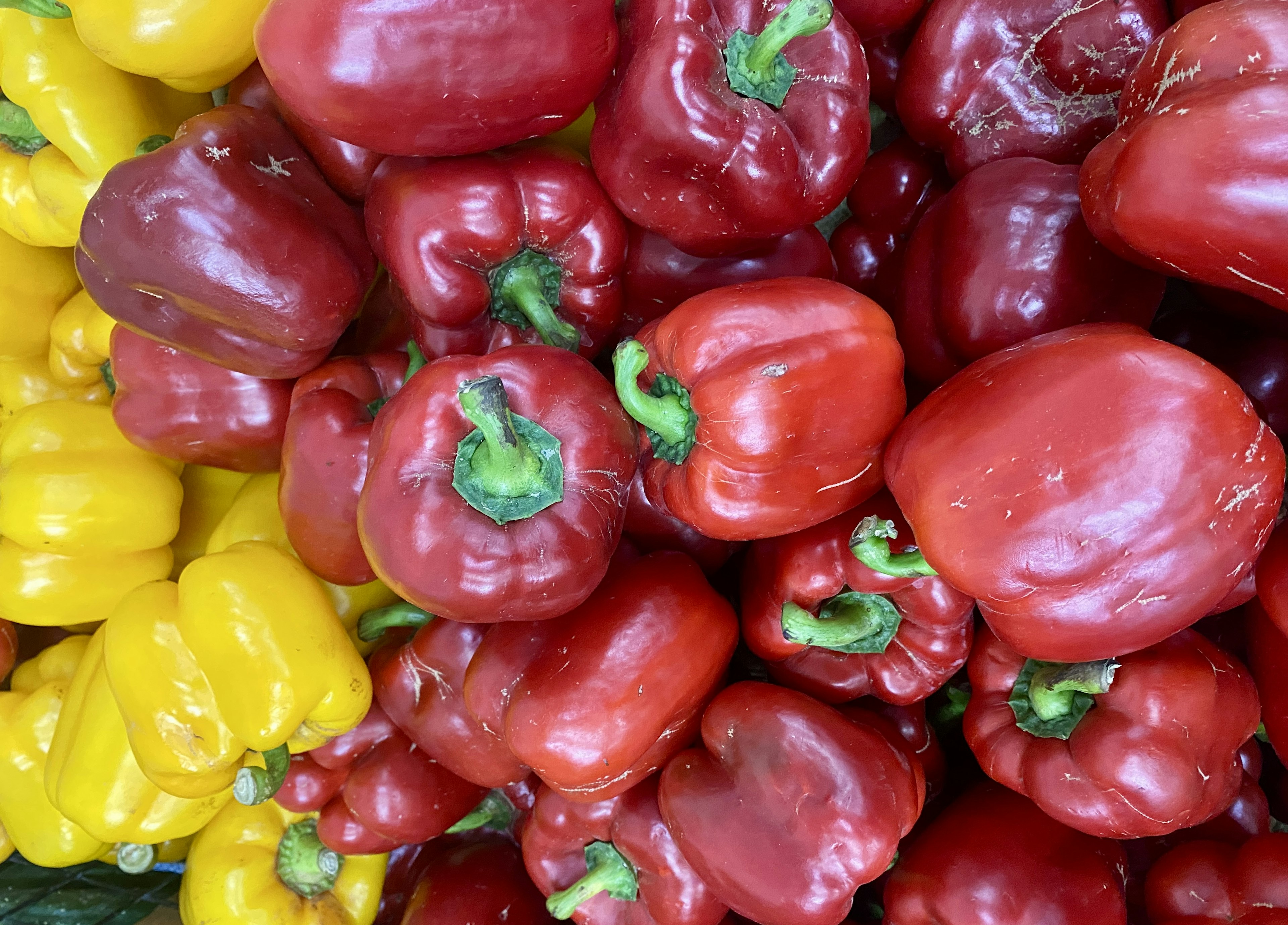 Vibrant red and yellow bell peppers stacked together