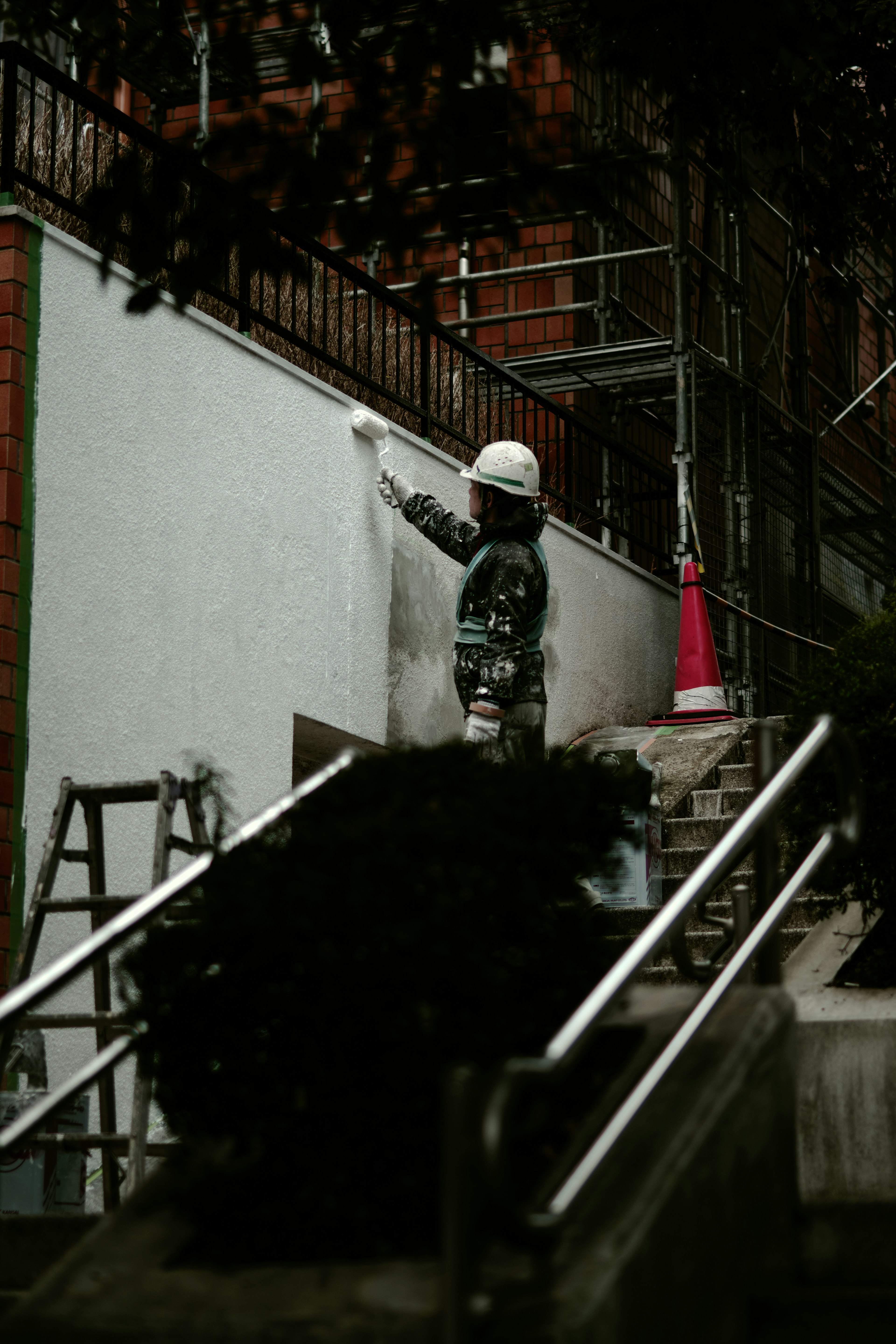 Trabajador pintando una pared en un sitio de construcción