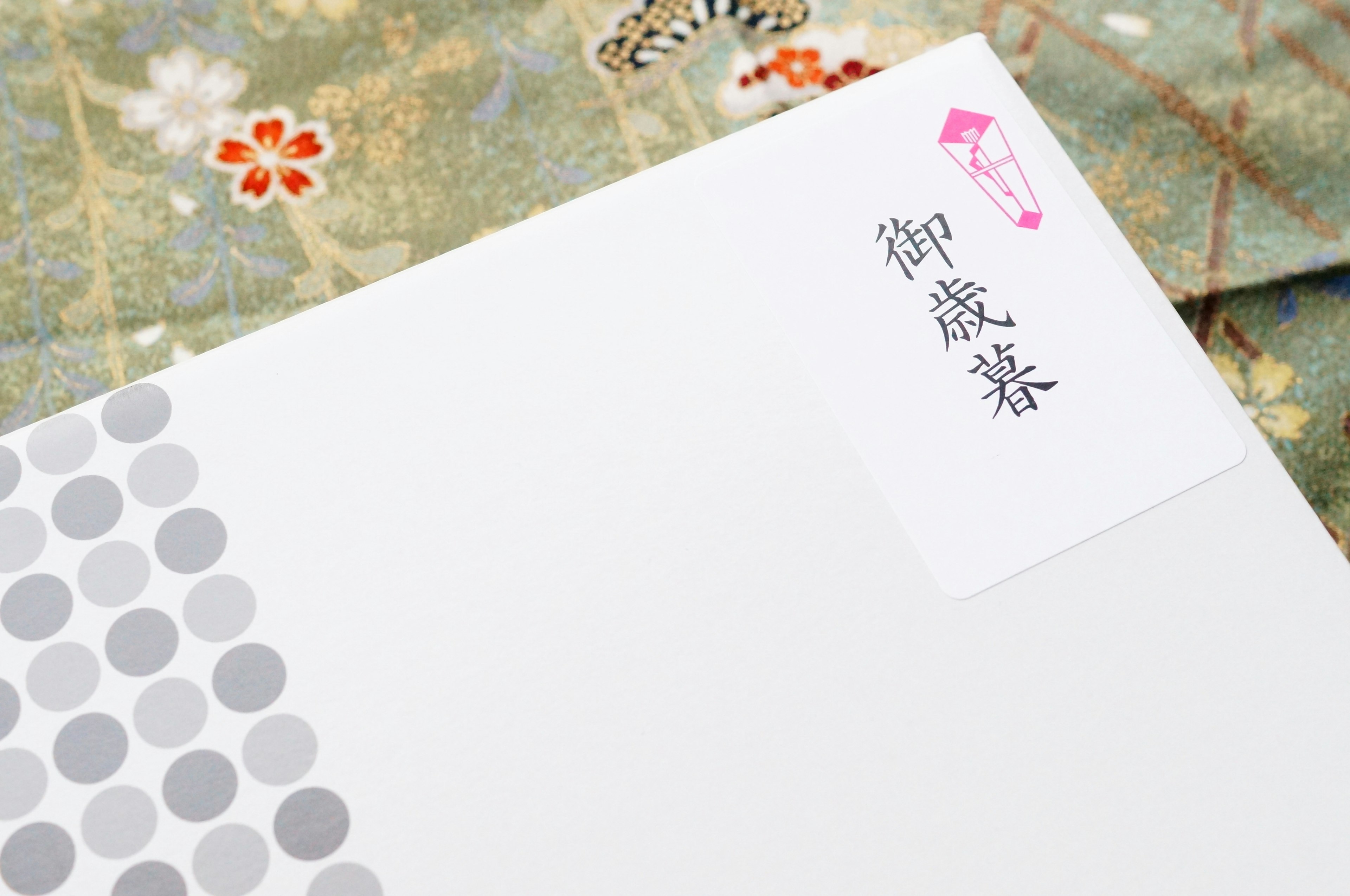 Image of a white envelope with silver dot pattern and handwritten label