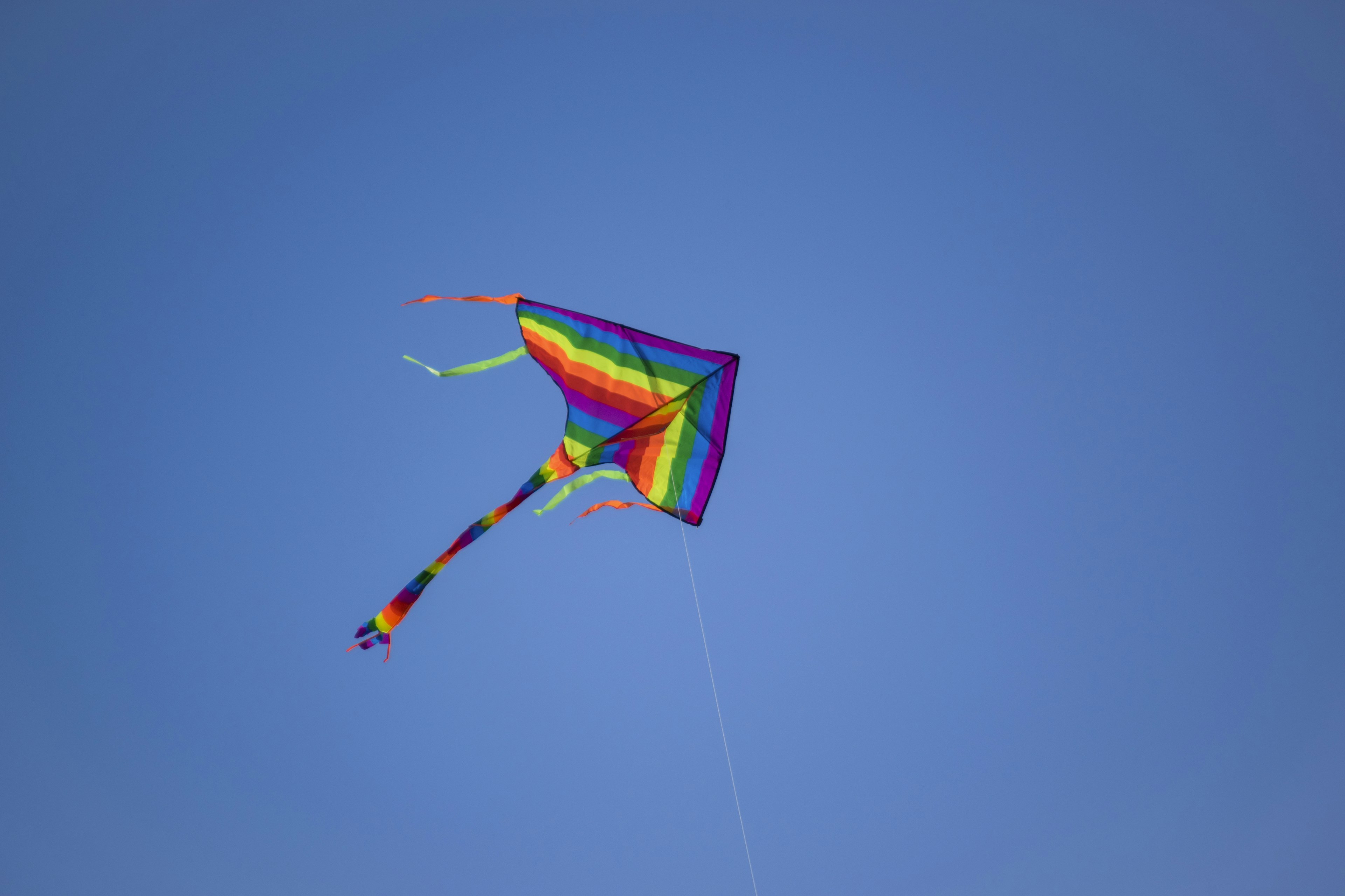 Rainbow kite soaring in a blue sky