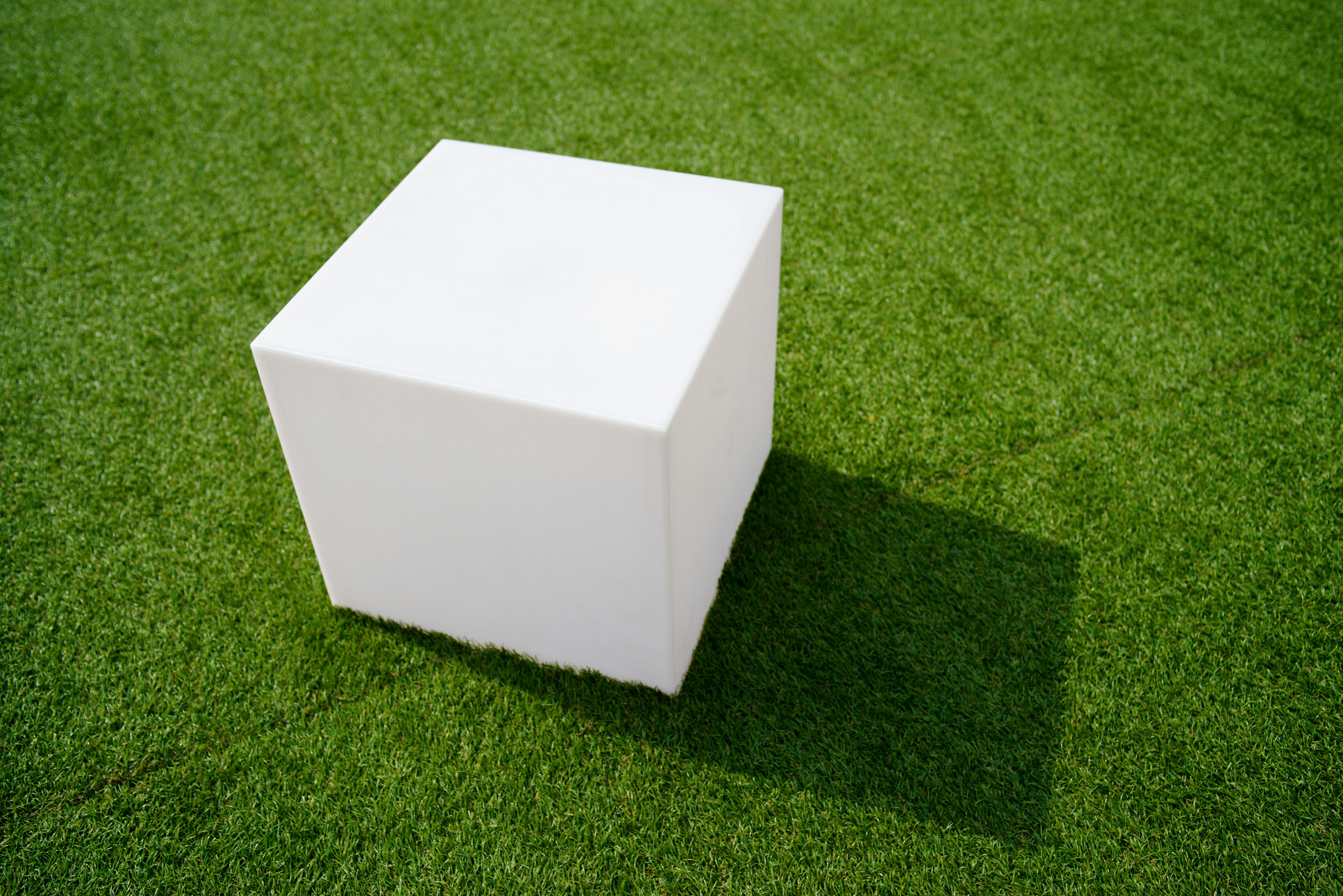 A white cube placed on green grass