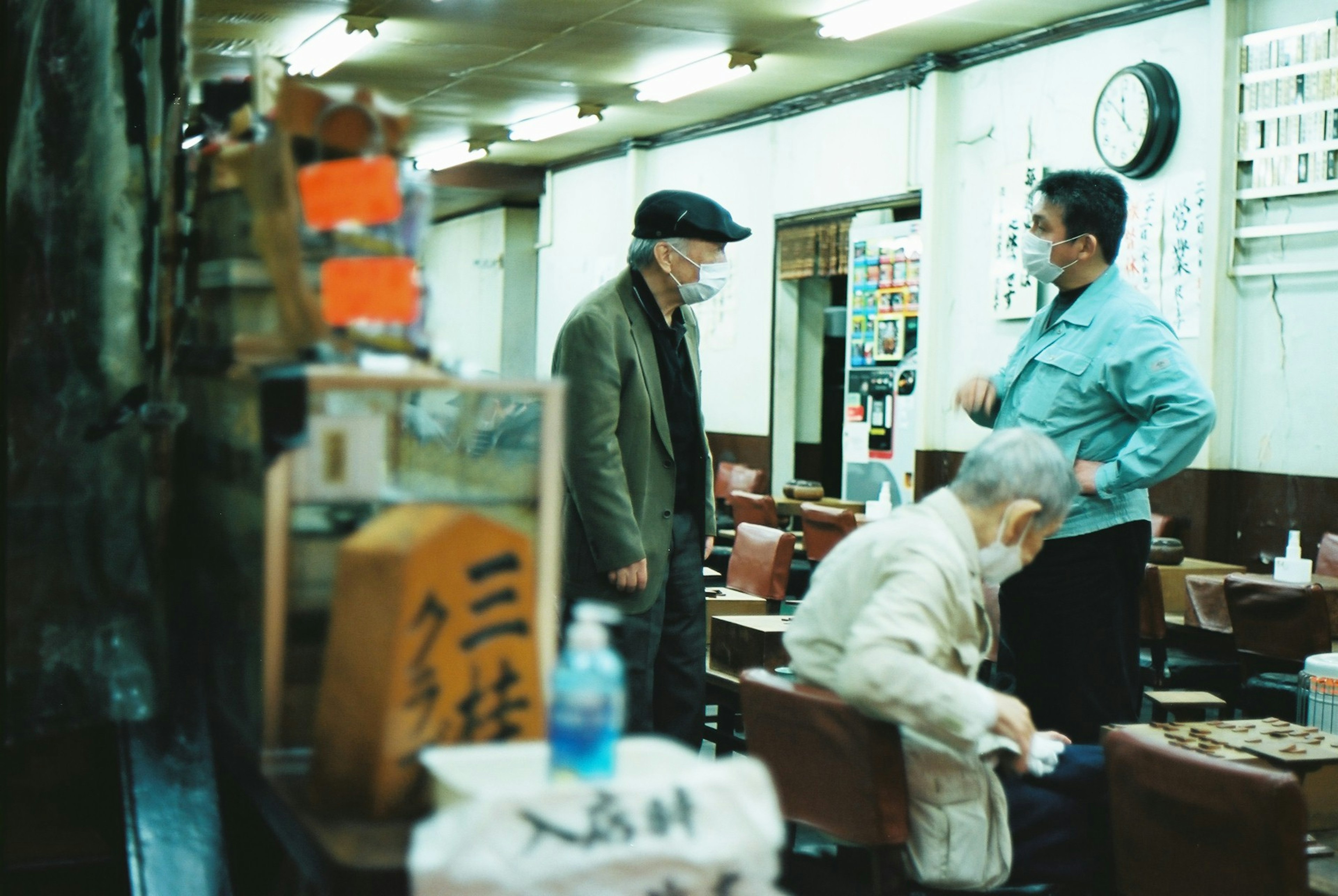 Hombres conversando en un viejo café con una mujer anciana sentada