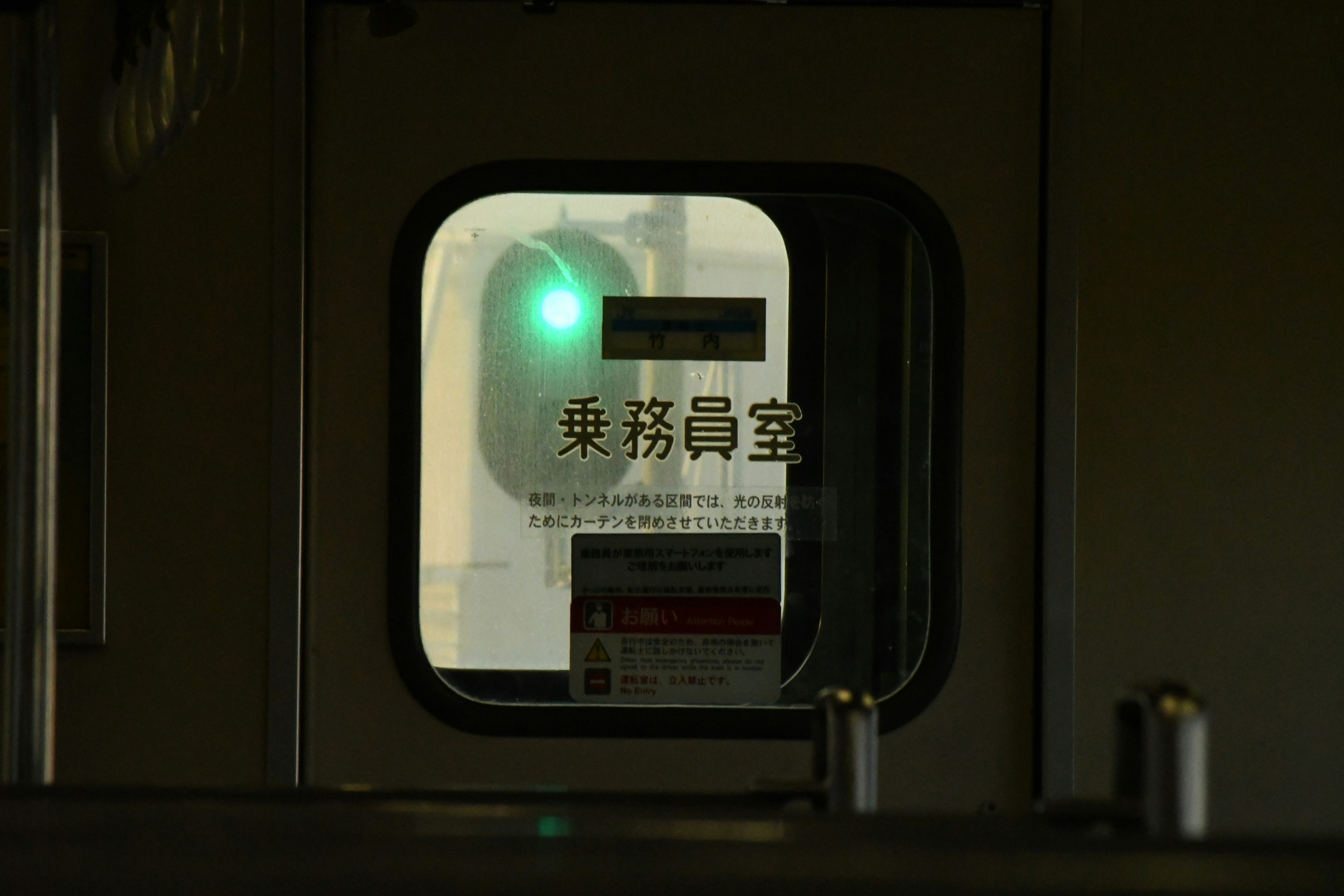 Interior view of a train station window showing a green signal