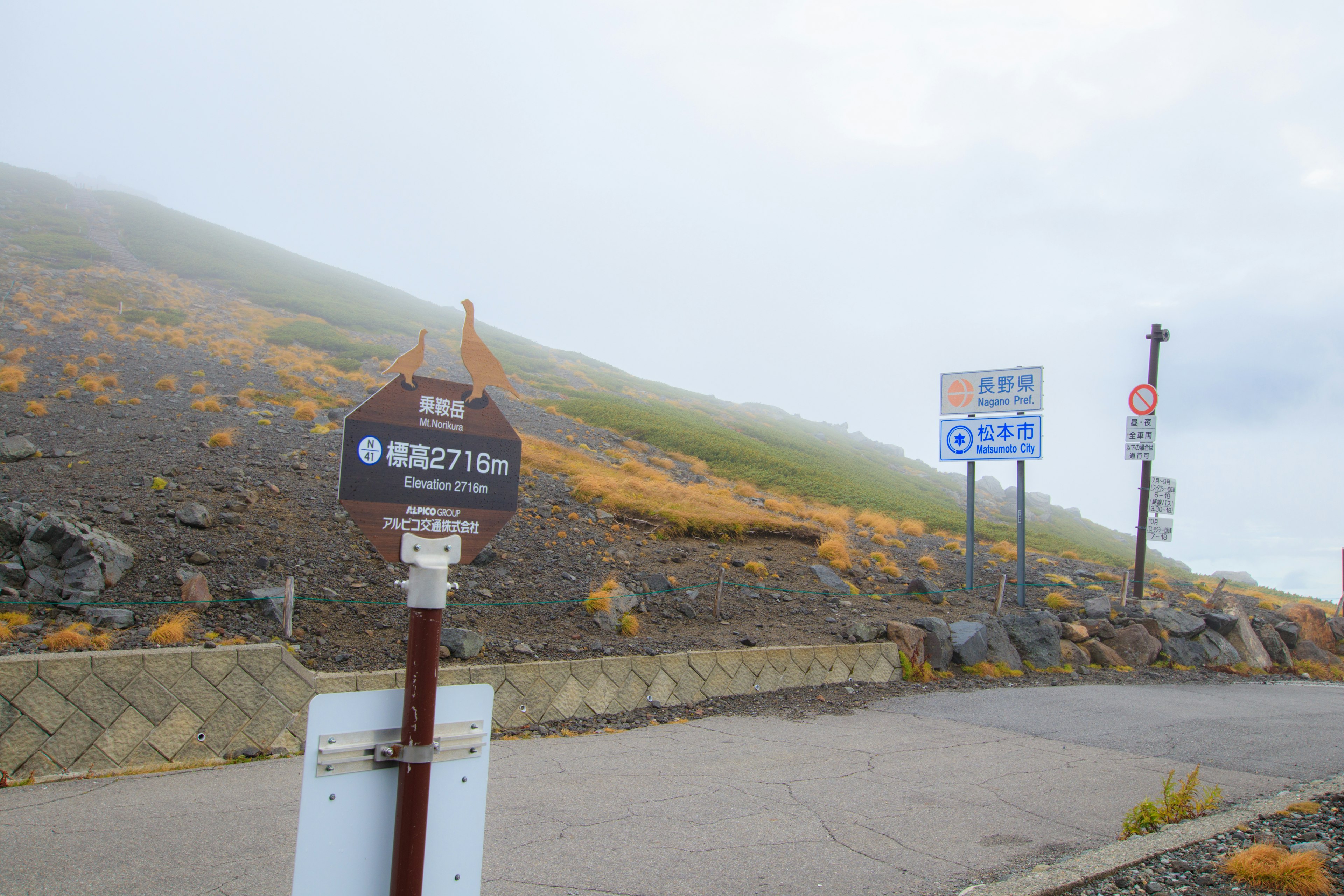 霧に覆われた山の風景と登山道の標識