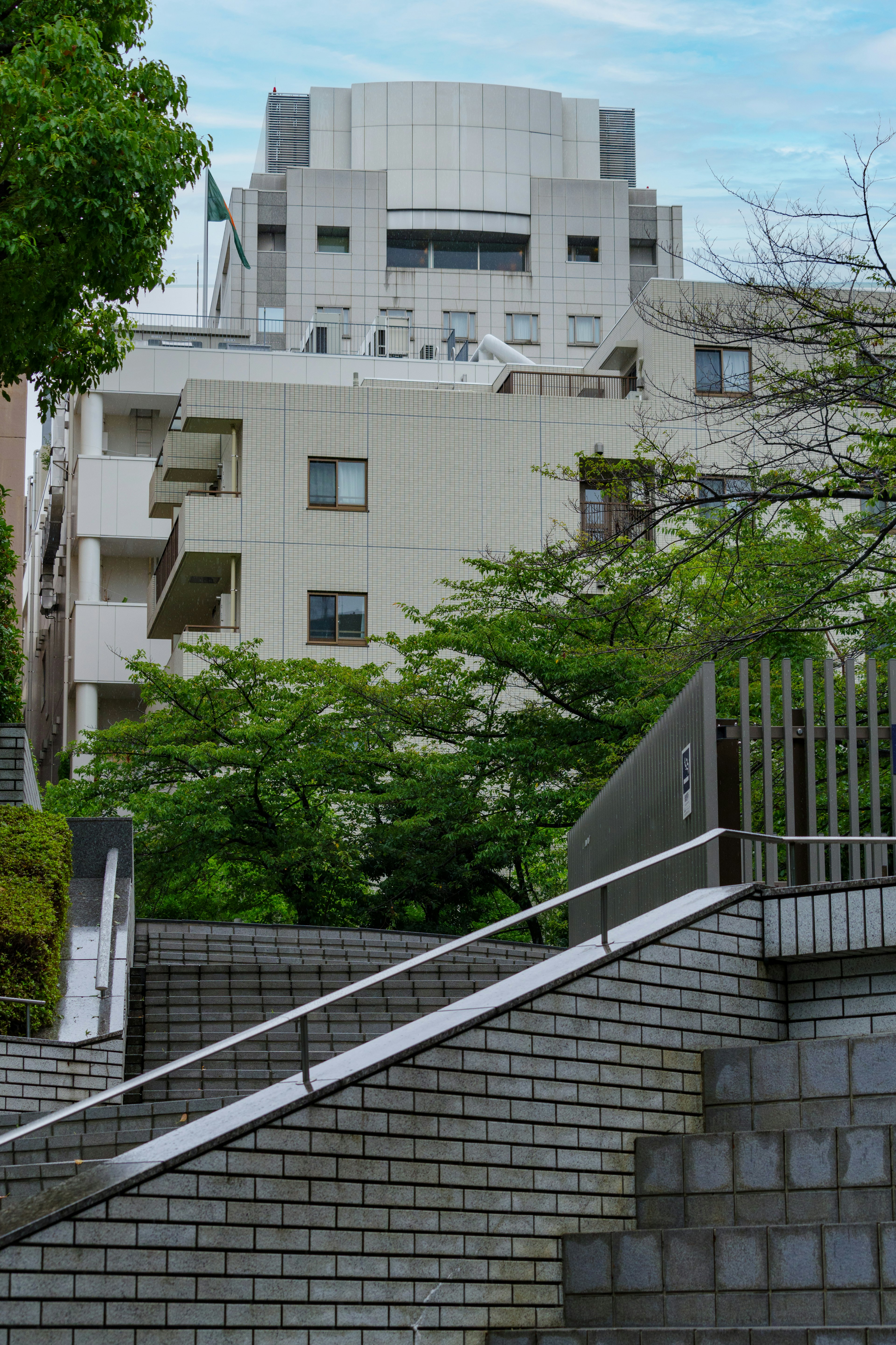 Bâtiment moderne entouré de verdure avec un escalier en pente