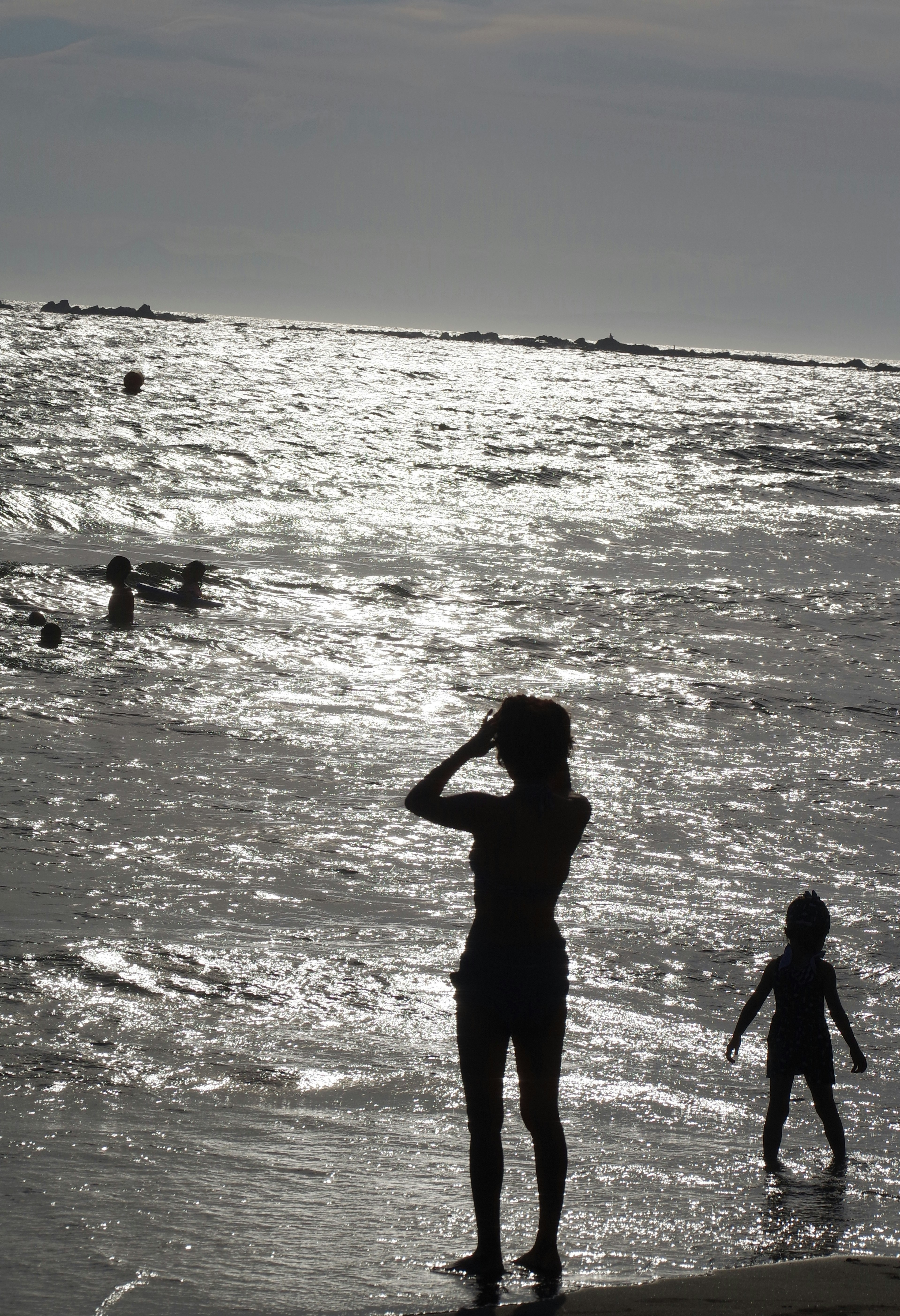 Silhouette of an adult and child playing at the beach