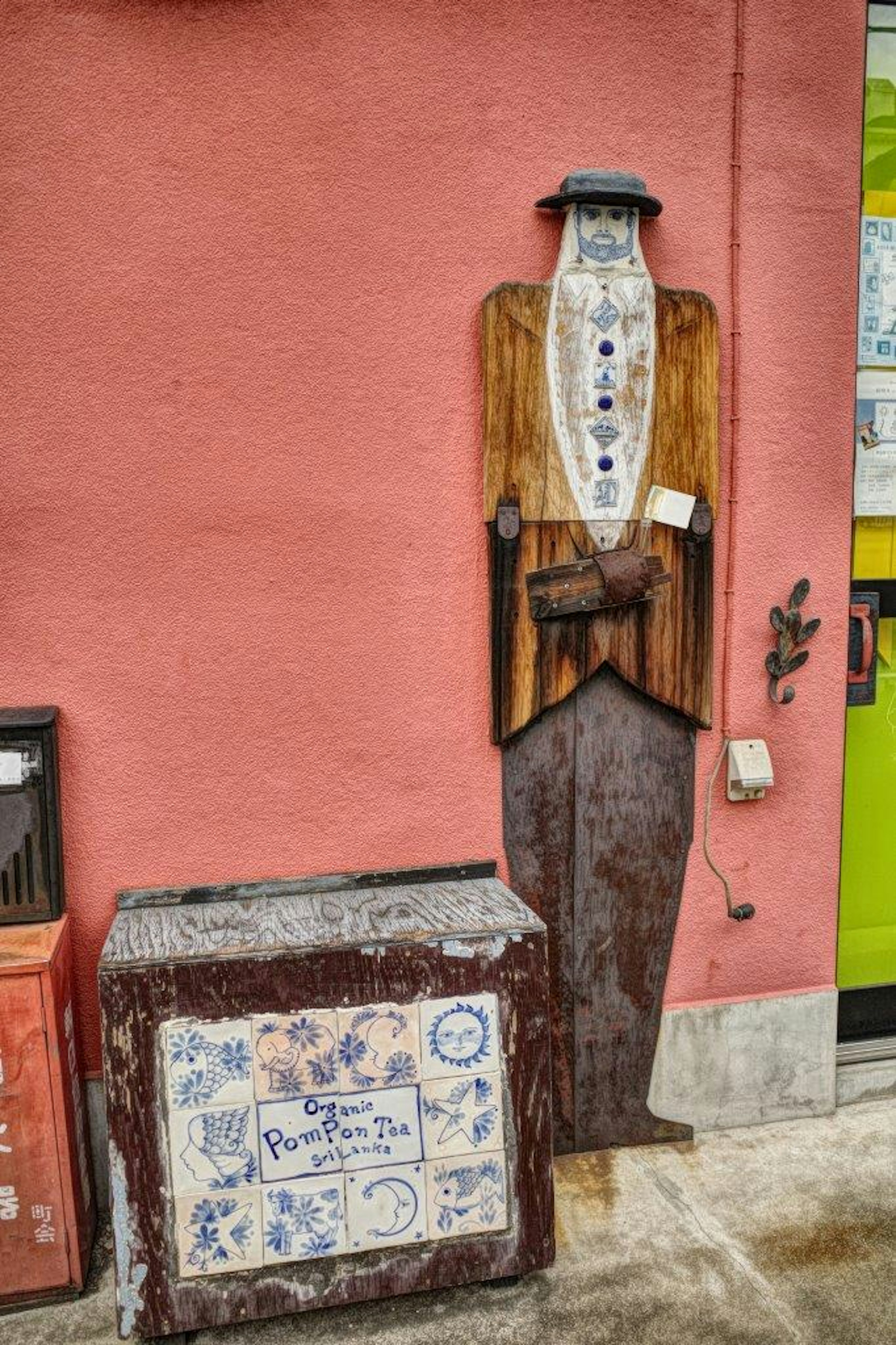 Einzigartiges Holzfigurenschild vor einer bunten Wand