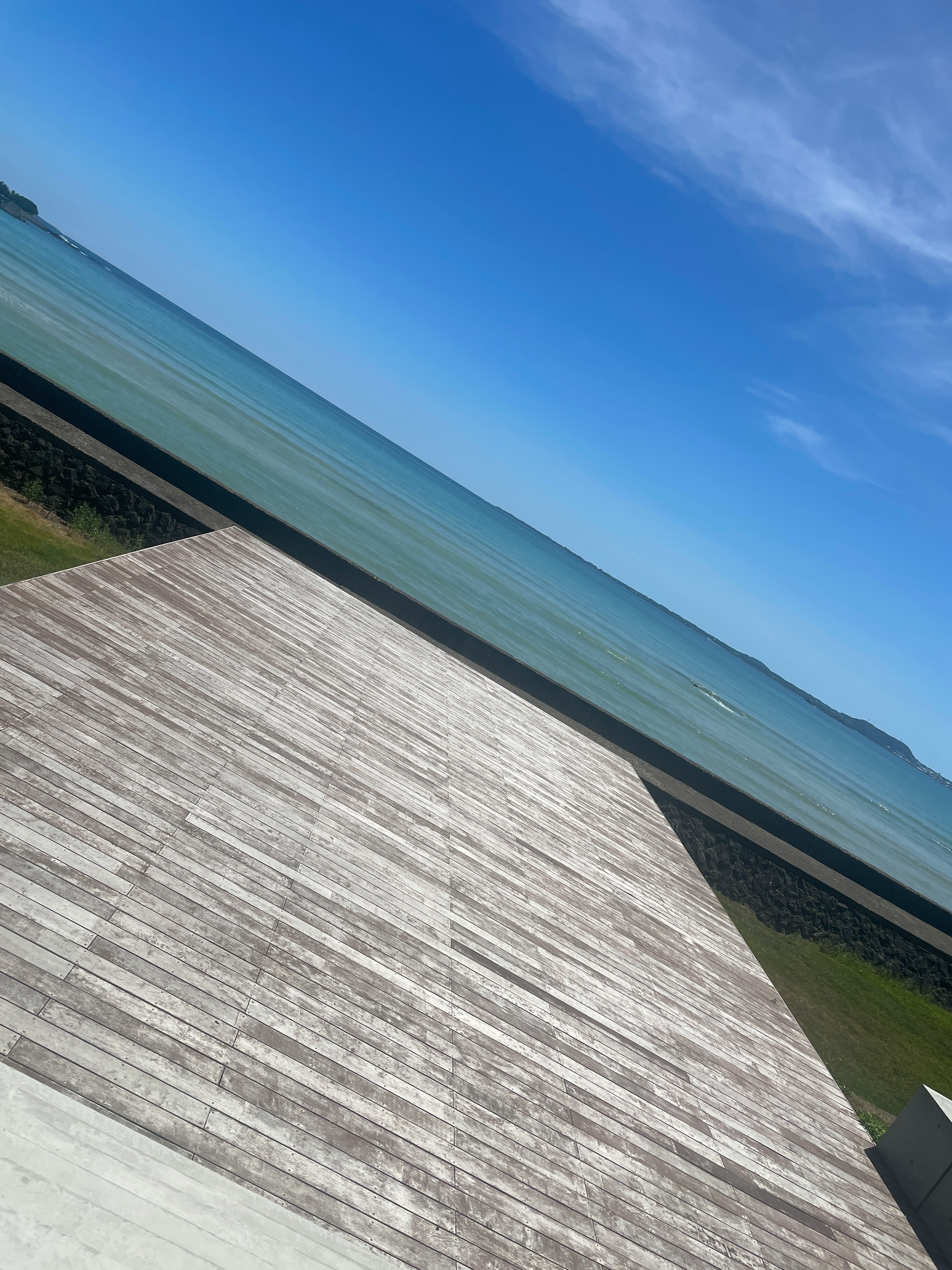 Wooden deck overlooking a blue sea and sky