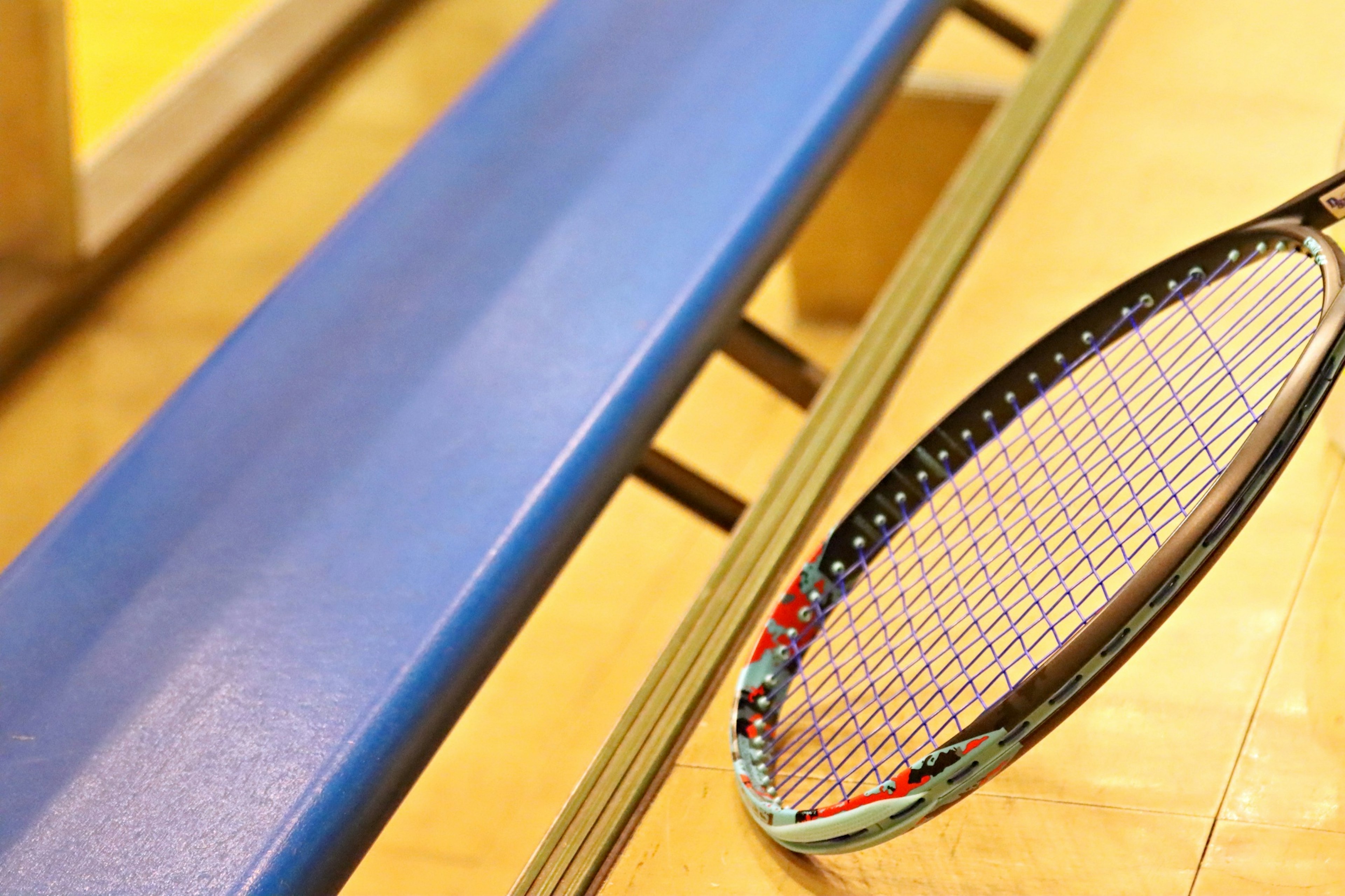 Nahaufnahme einer blauen Bank und eines Tennisschlägers