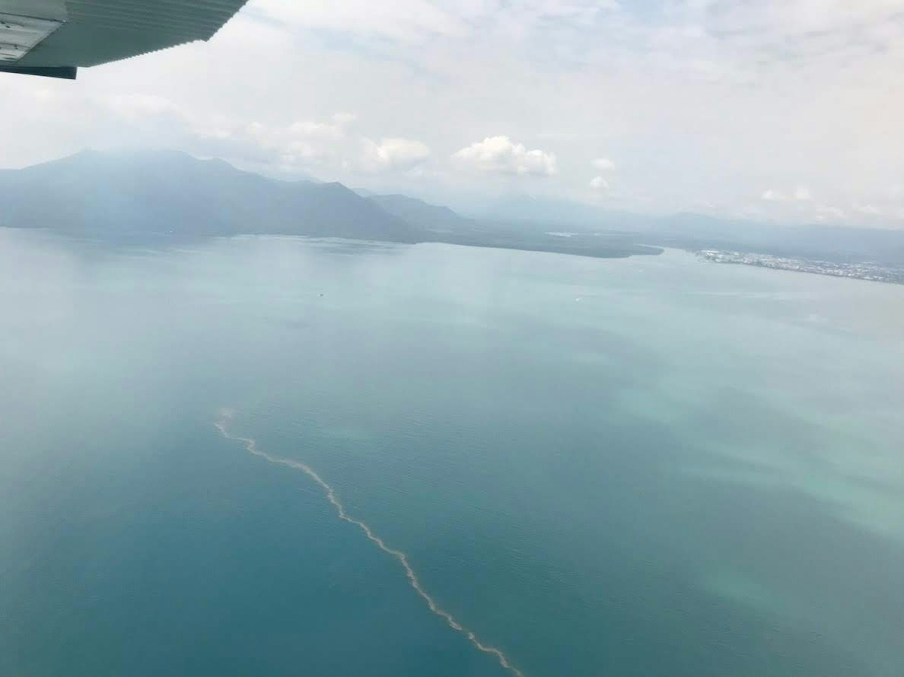 Aerial view of blue ocean and distant mountains