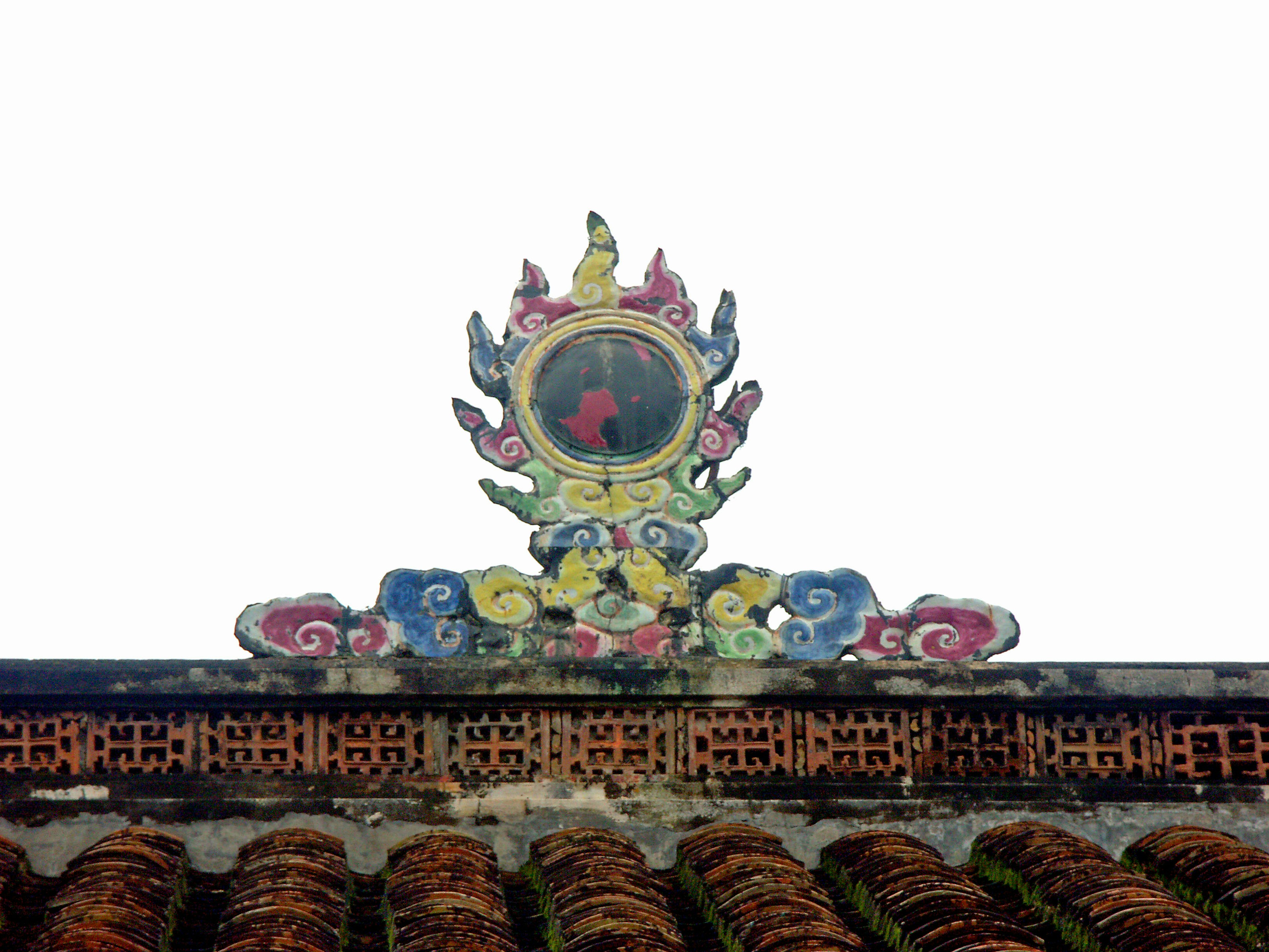 Colorful decorative symbol on top of a tiled roof