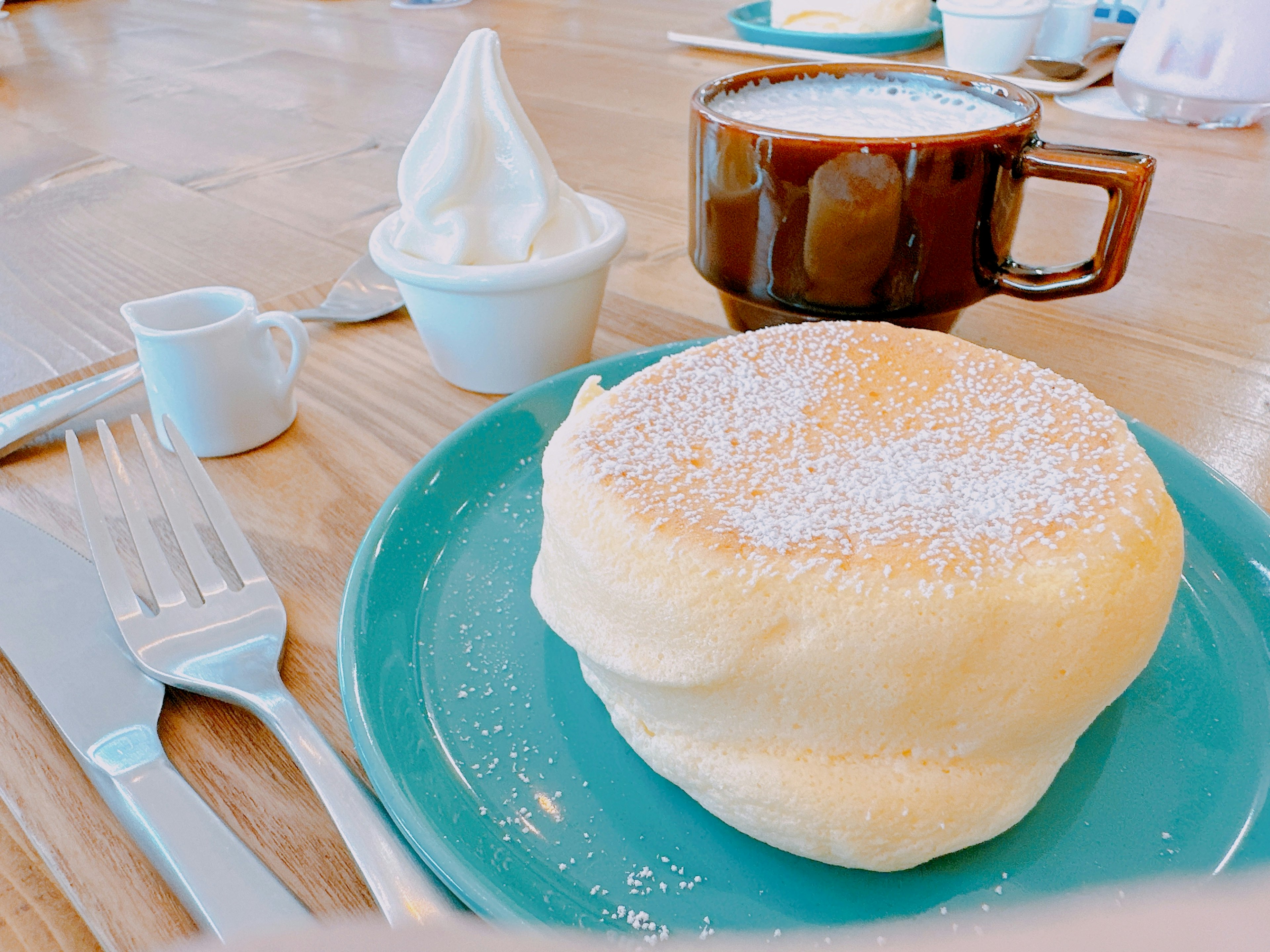 Pancake lembut dengan secangkir kopi di atas meja kayu