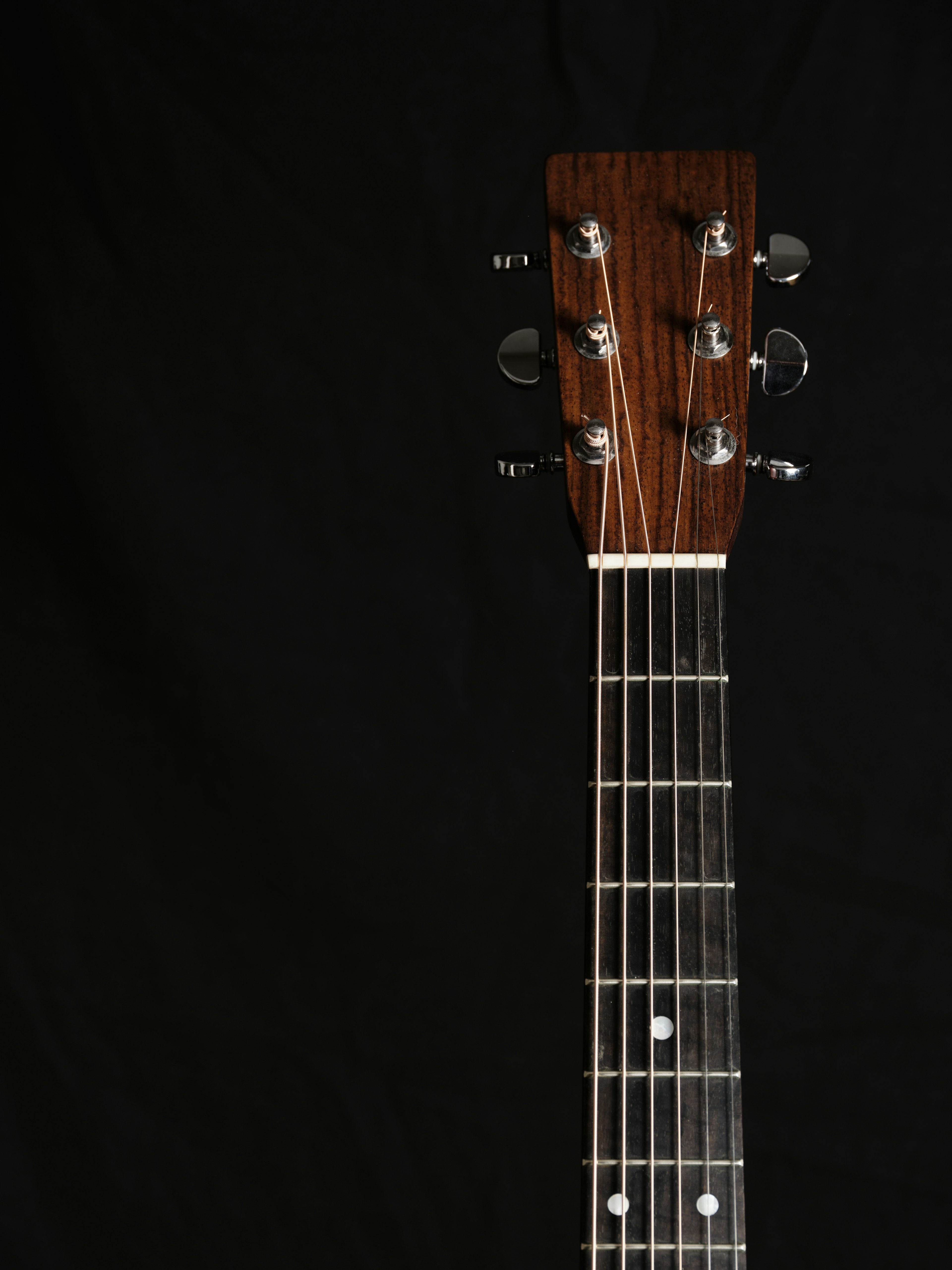 Guitar neck and headstock positioned against a black background