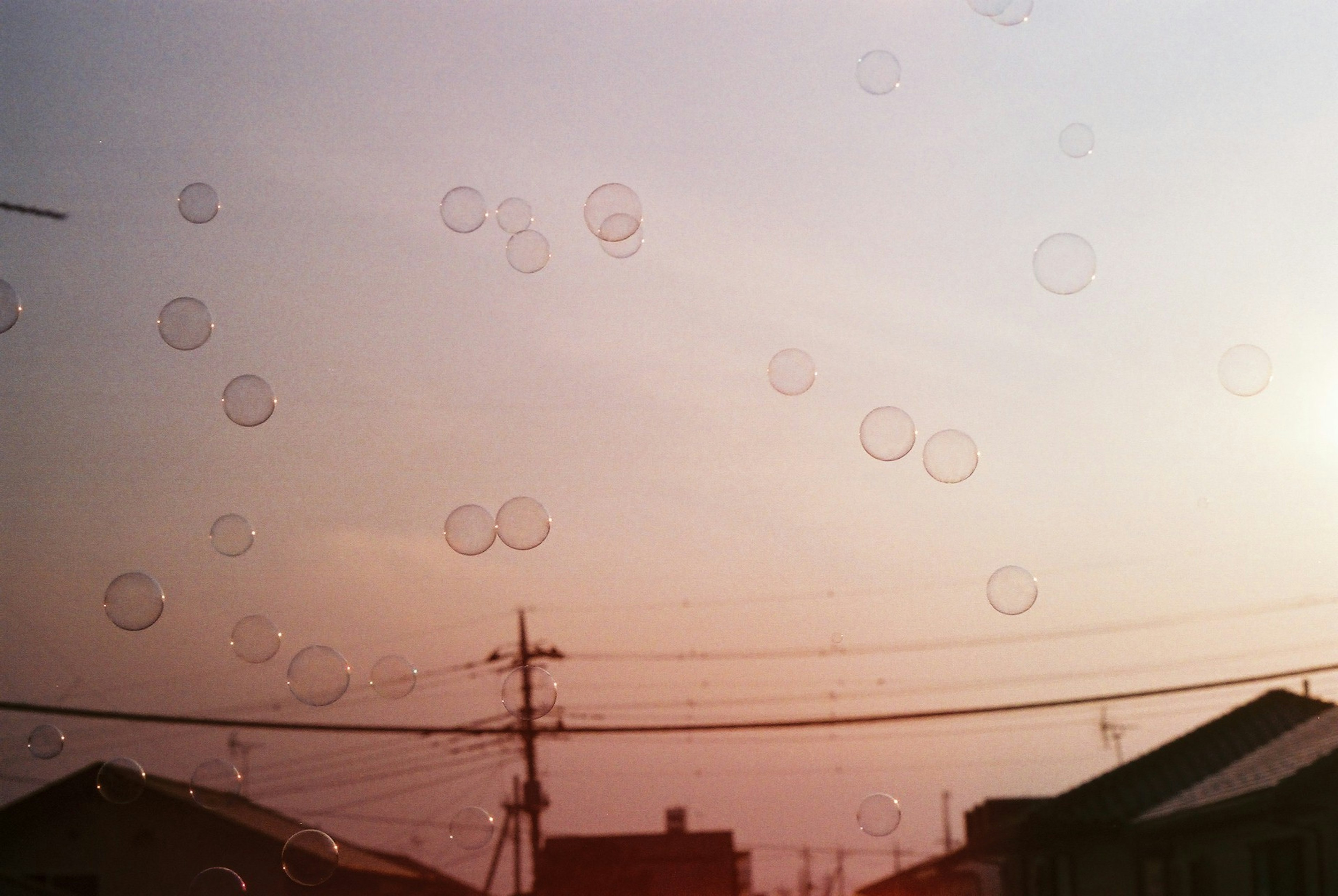 Landscape with bubbles floating in the sky and power lines