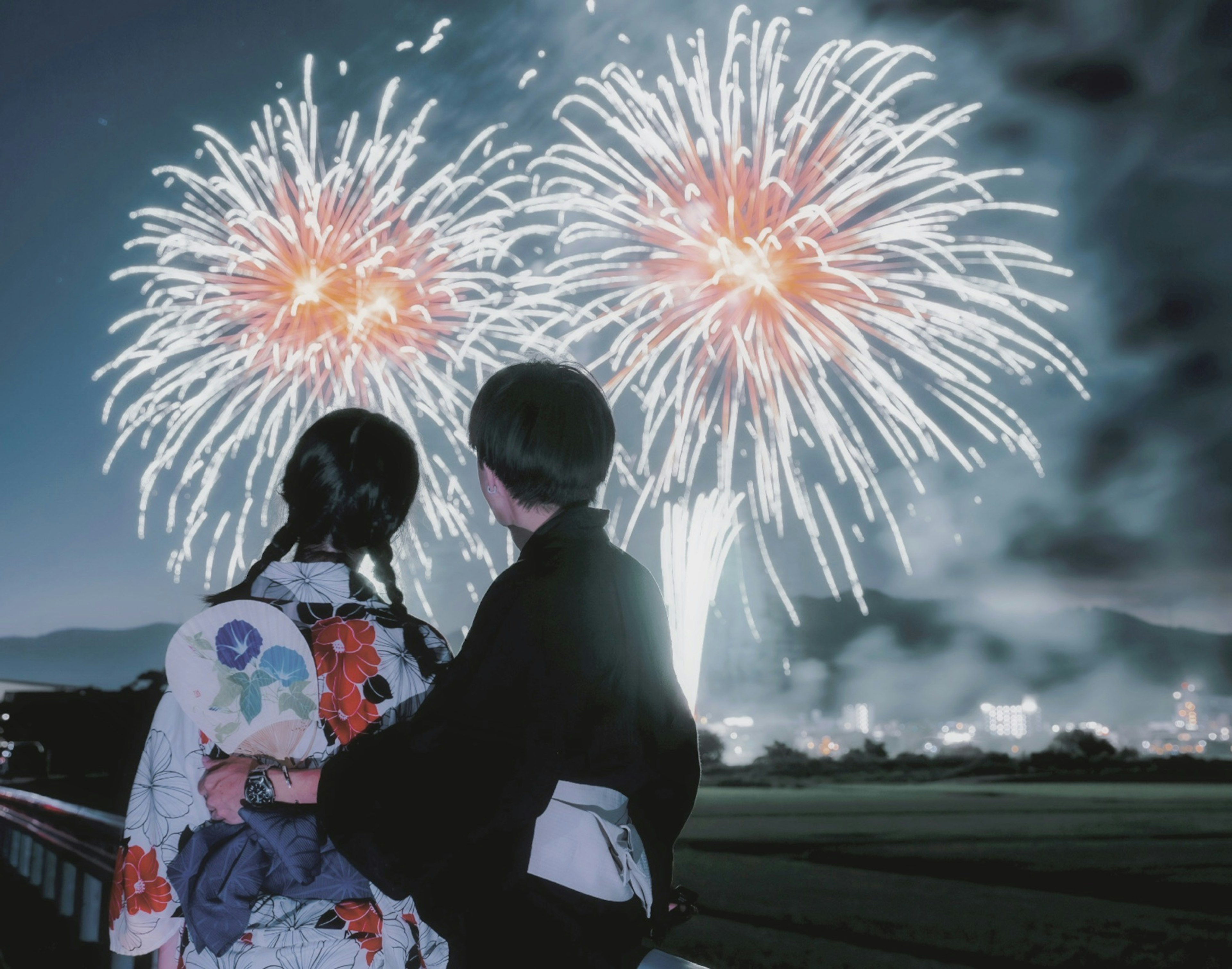 Silhouette di due persone in kimono che guardano i fuochi d'artificio