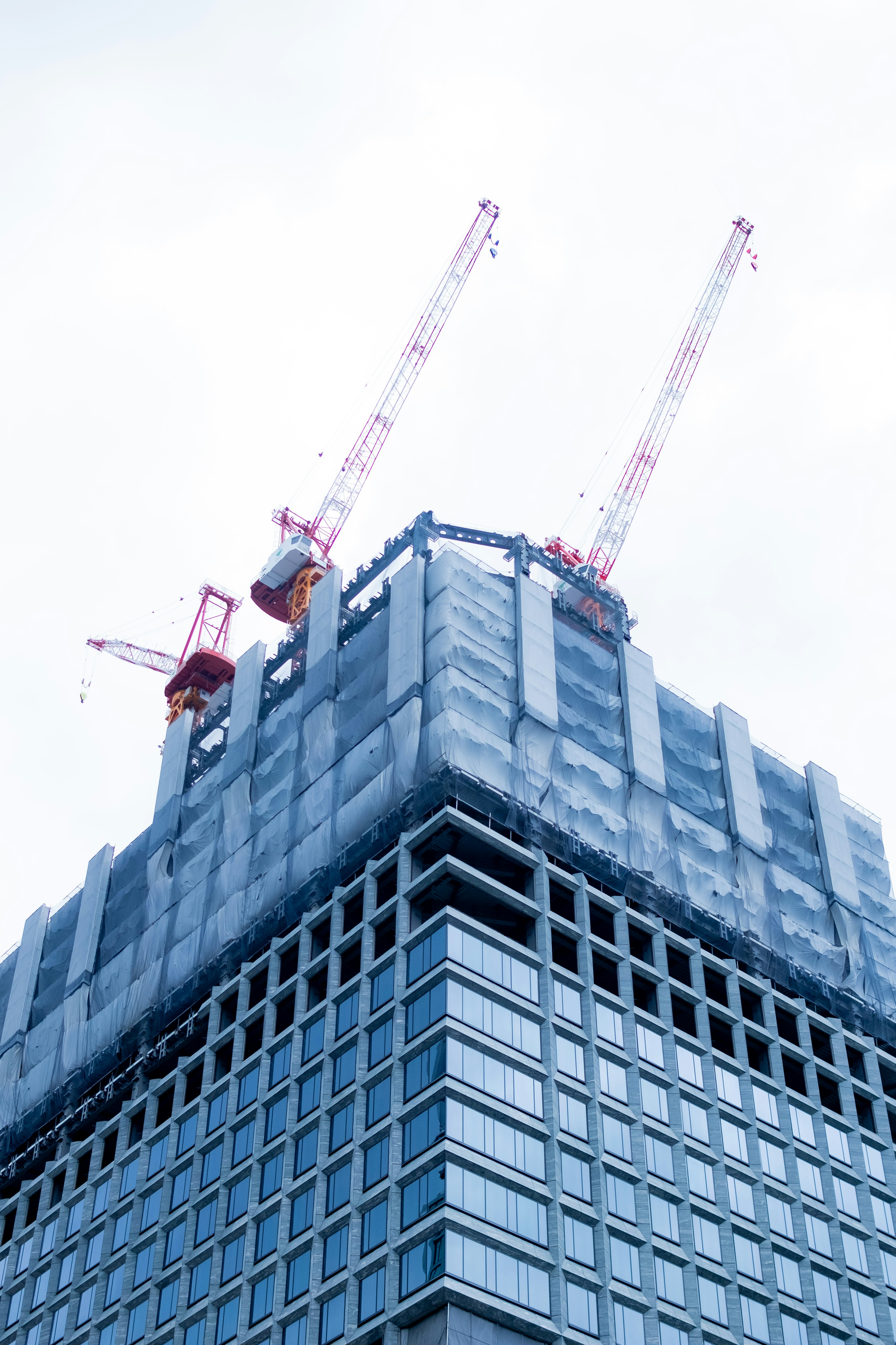 Cantiere di costruzione di un grattacielo con gru e cielo nuvoloso