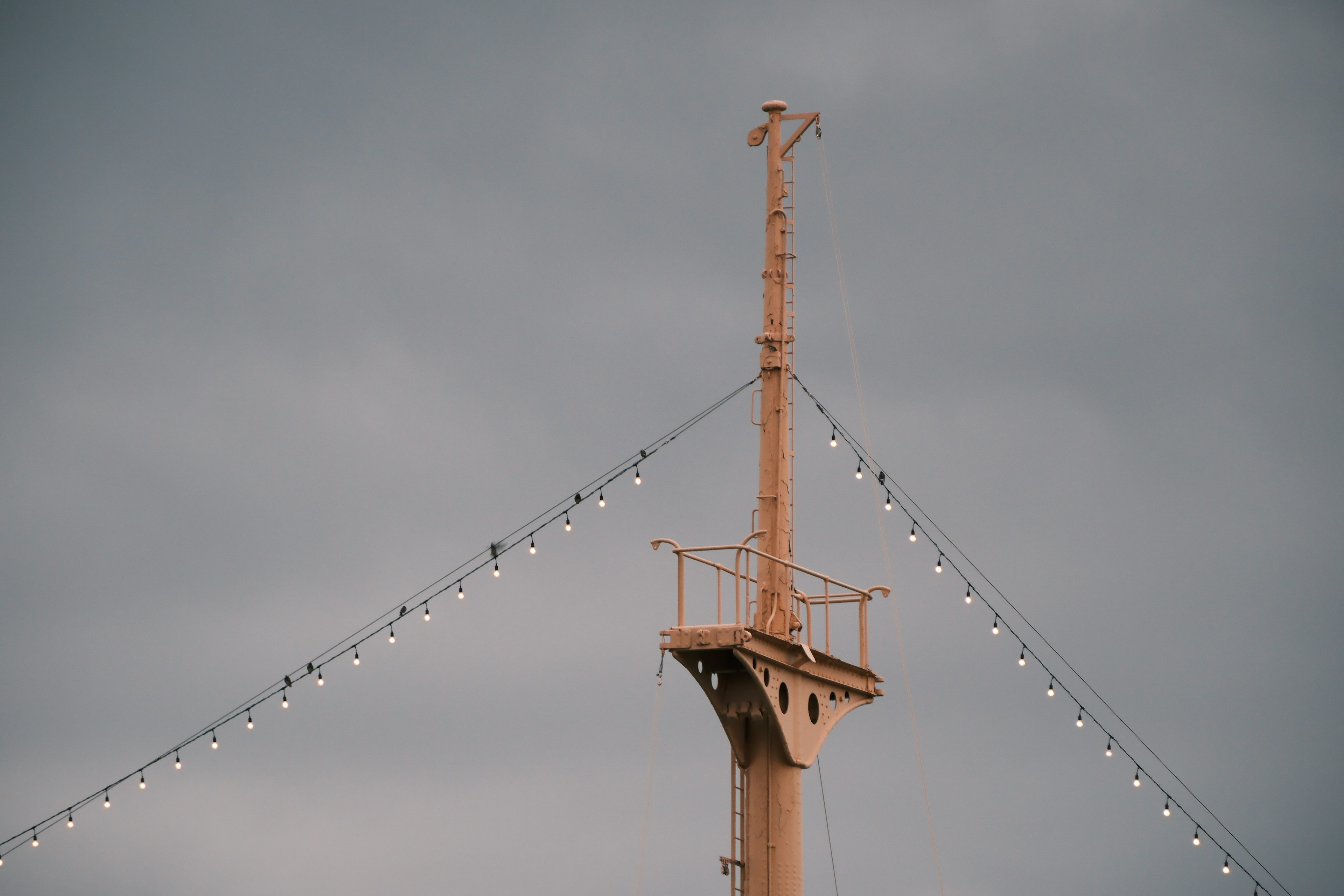 Oranger Mast unter einem bewölkten Himmel mit dekorativen Lichtern