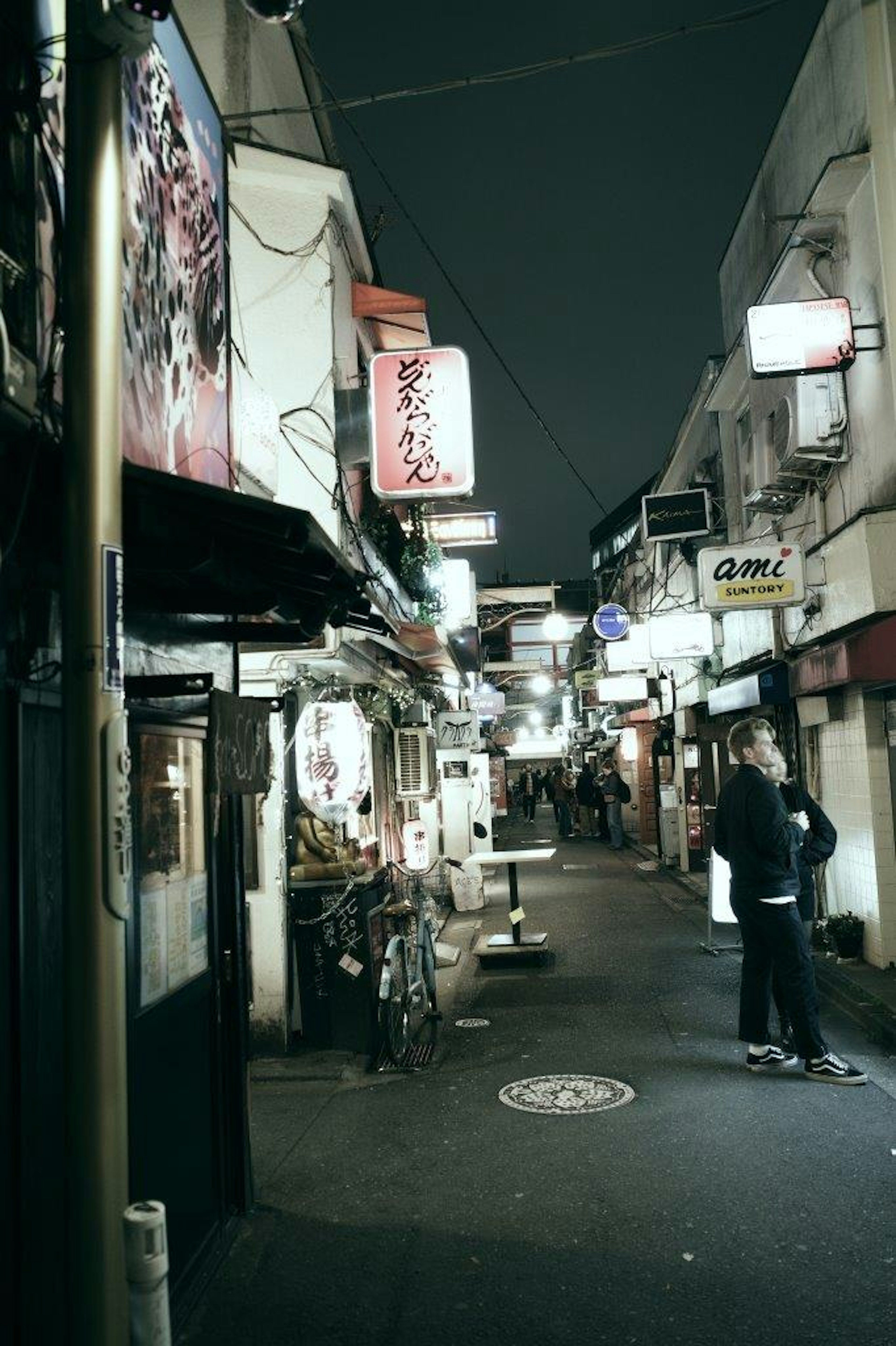 밤에 일본의 좁은 거리와 음식점 간판과 한 사람