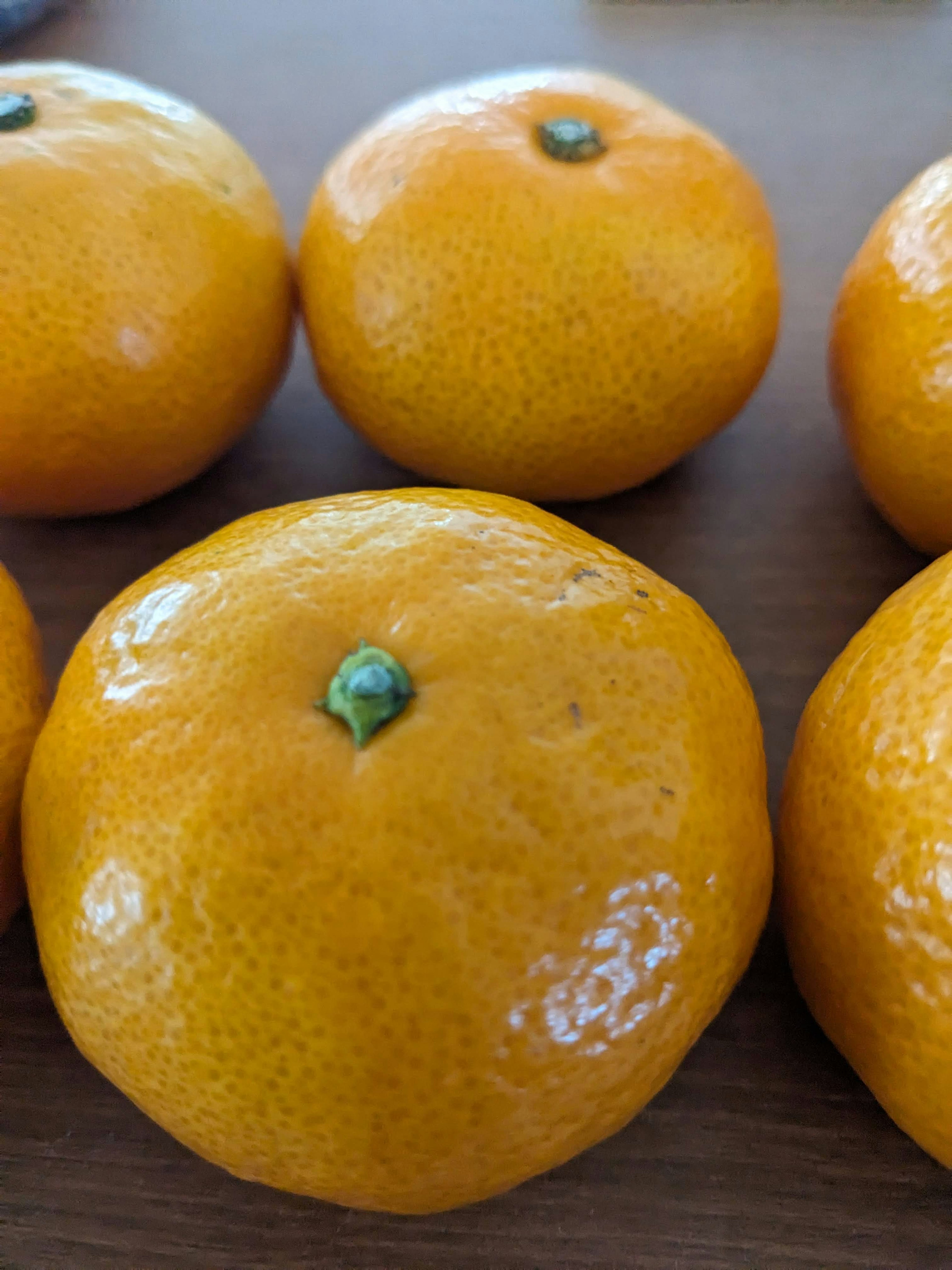 A cluster of vibrant orange mandarins arranged on a wooden table