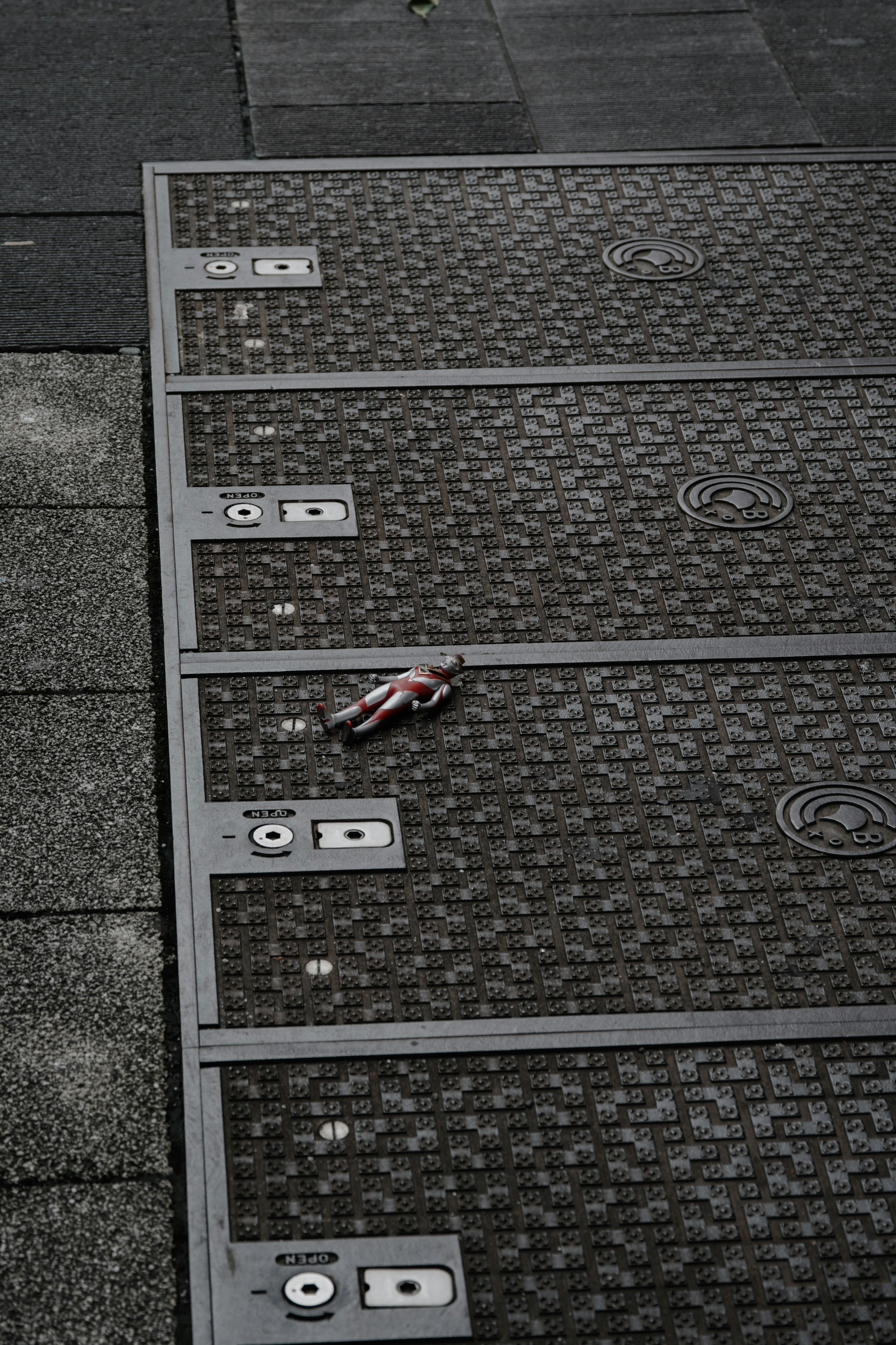 A beverage can lying on patterned pavement