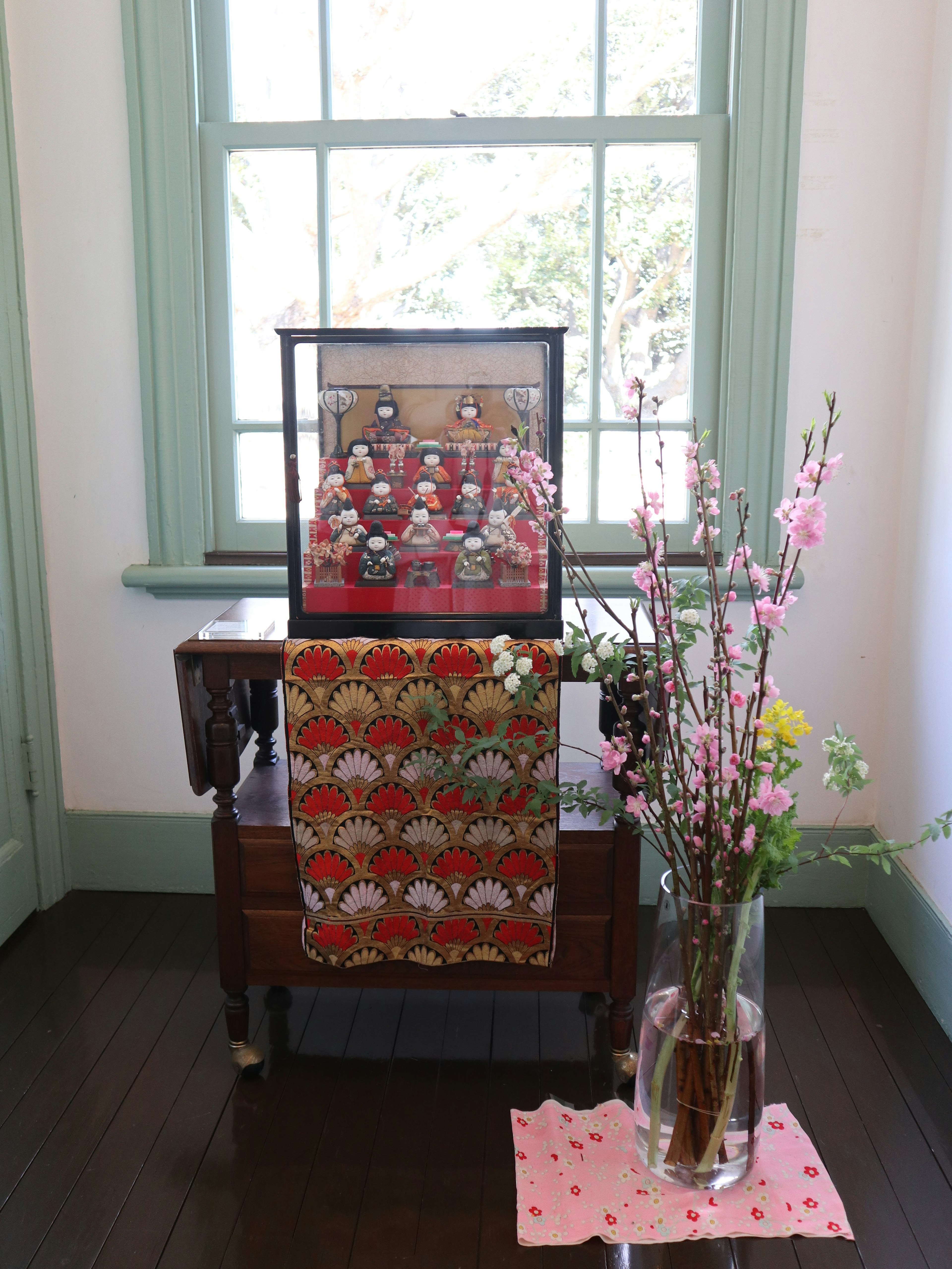 Decorative items and flowers arranged on a table near a window