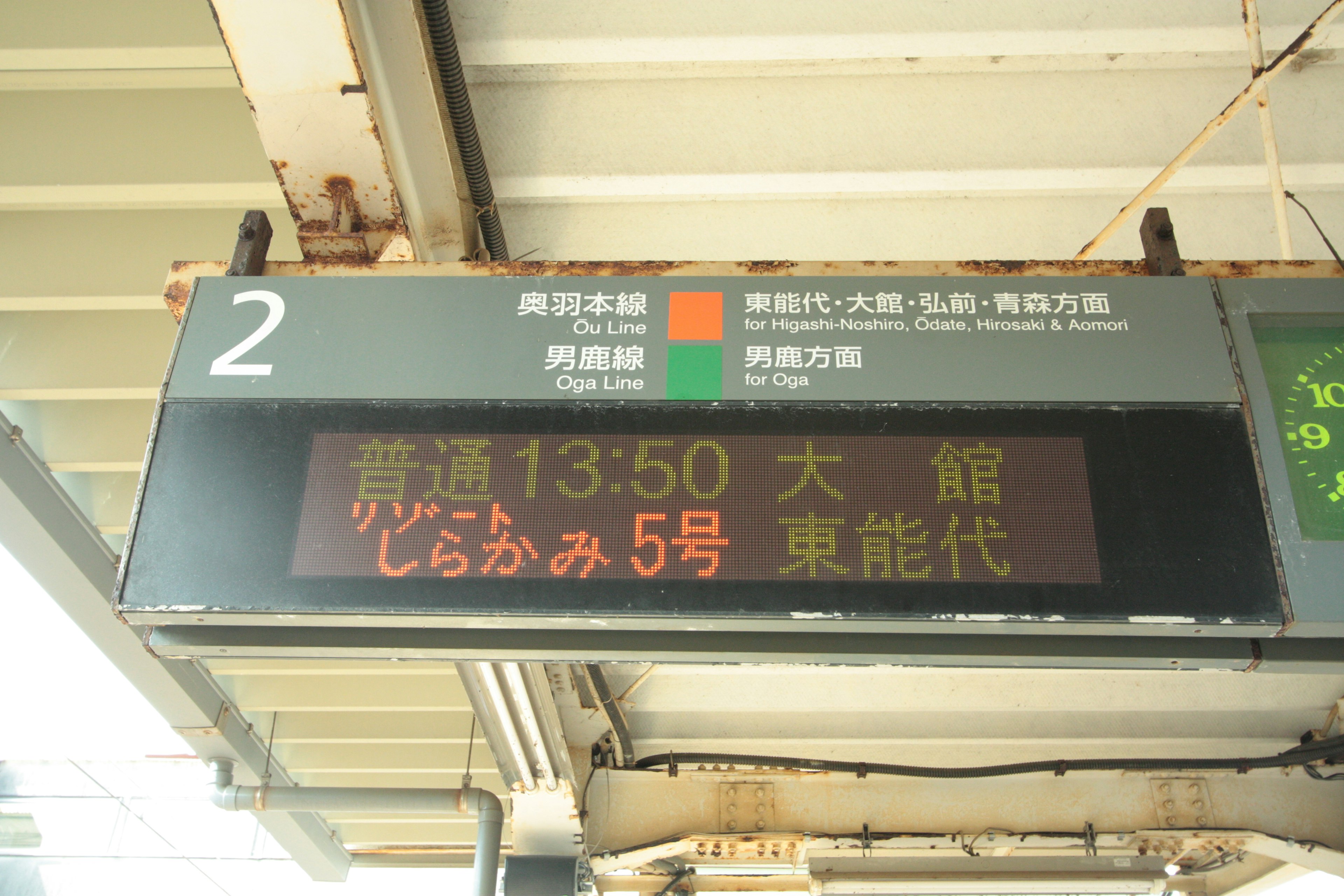 駅の表示板に書かれた列車情報と時刻