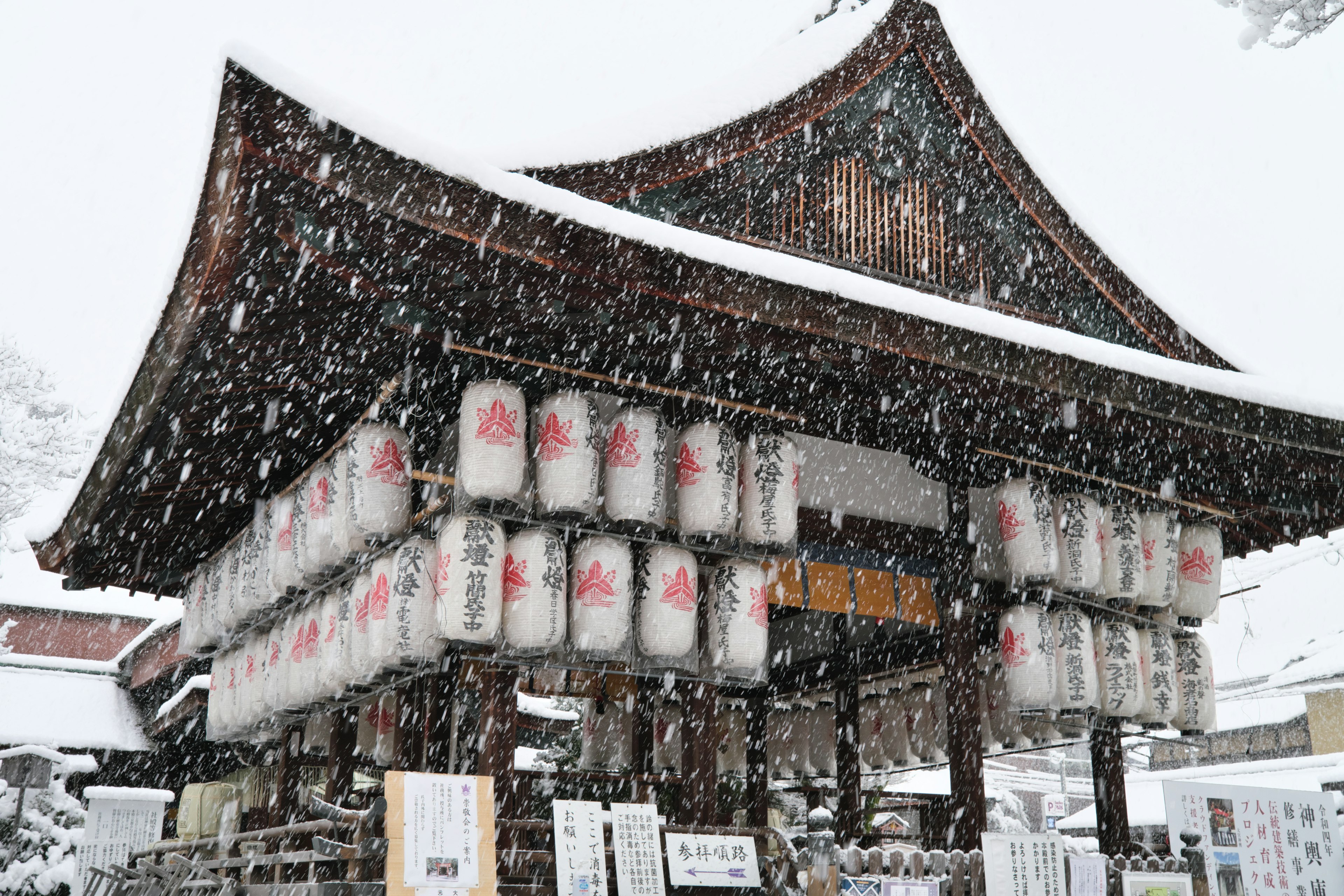 Traditional Japanese gate with lanterns in a snowy landscape