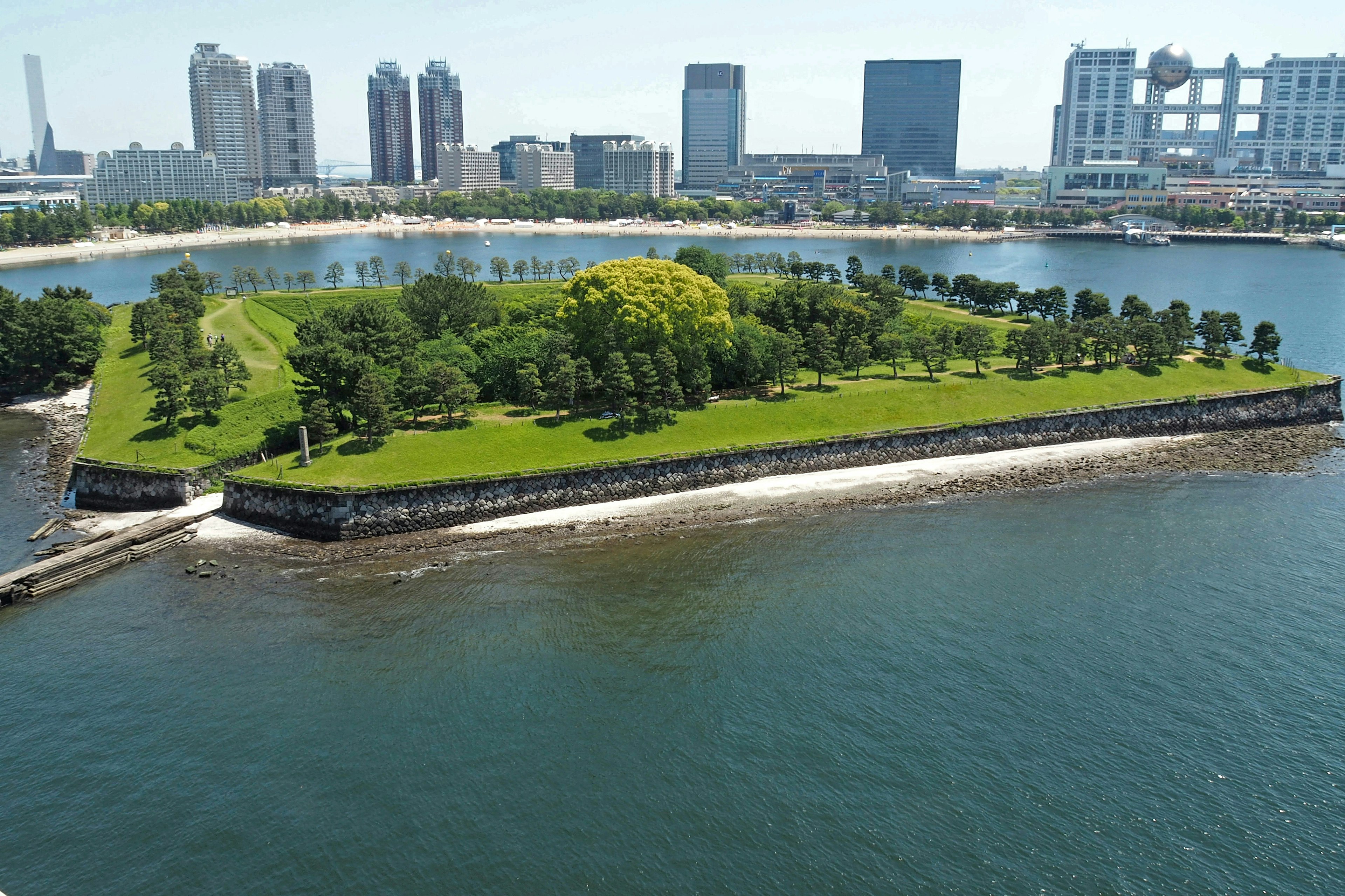 Green island with trees surrounded by urban skyline