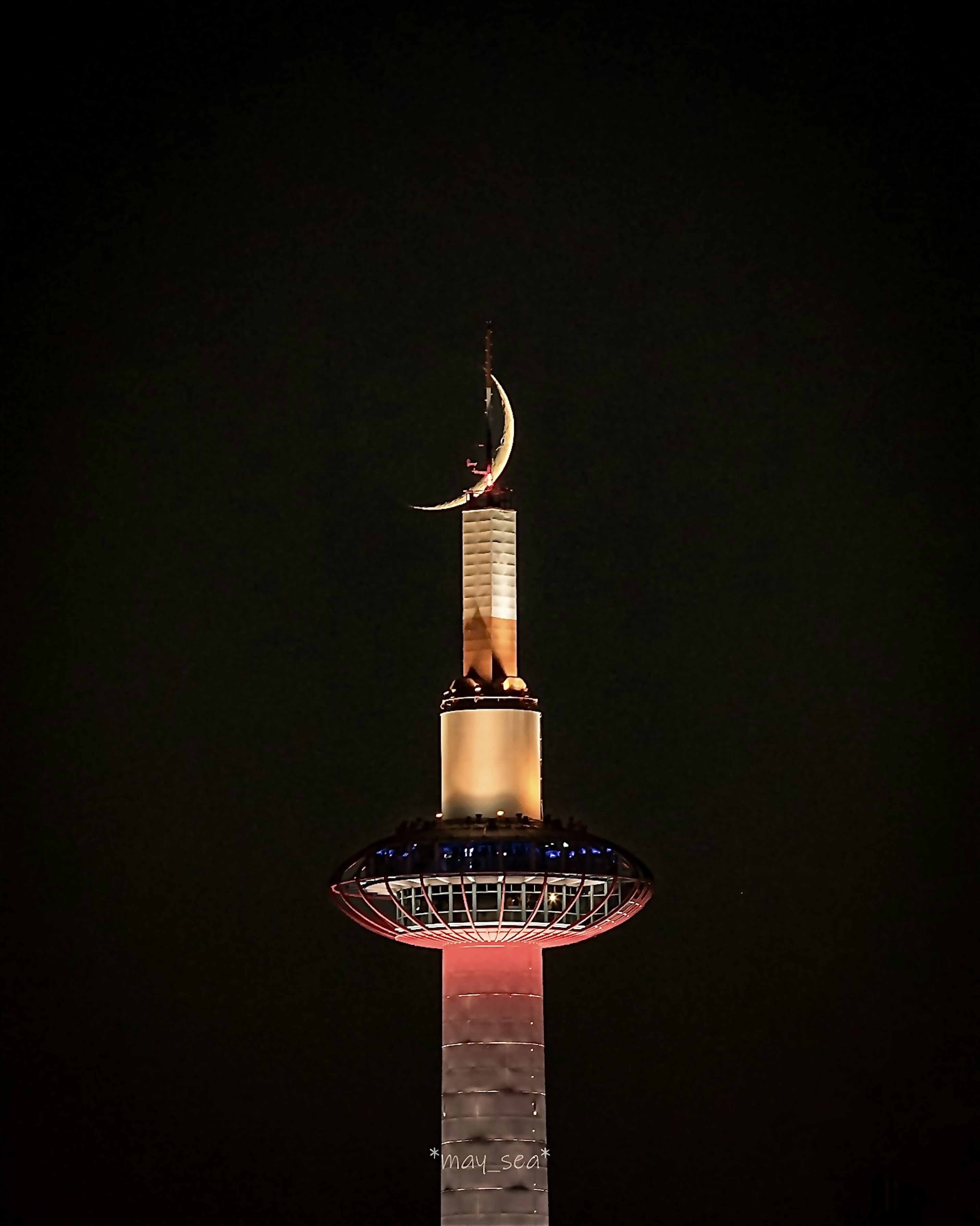 Croissant doré au sommet d'un minaret de mosquée illuminé sur fond noir