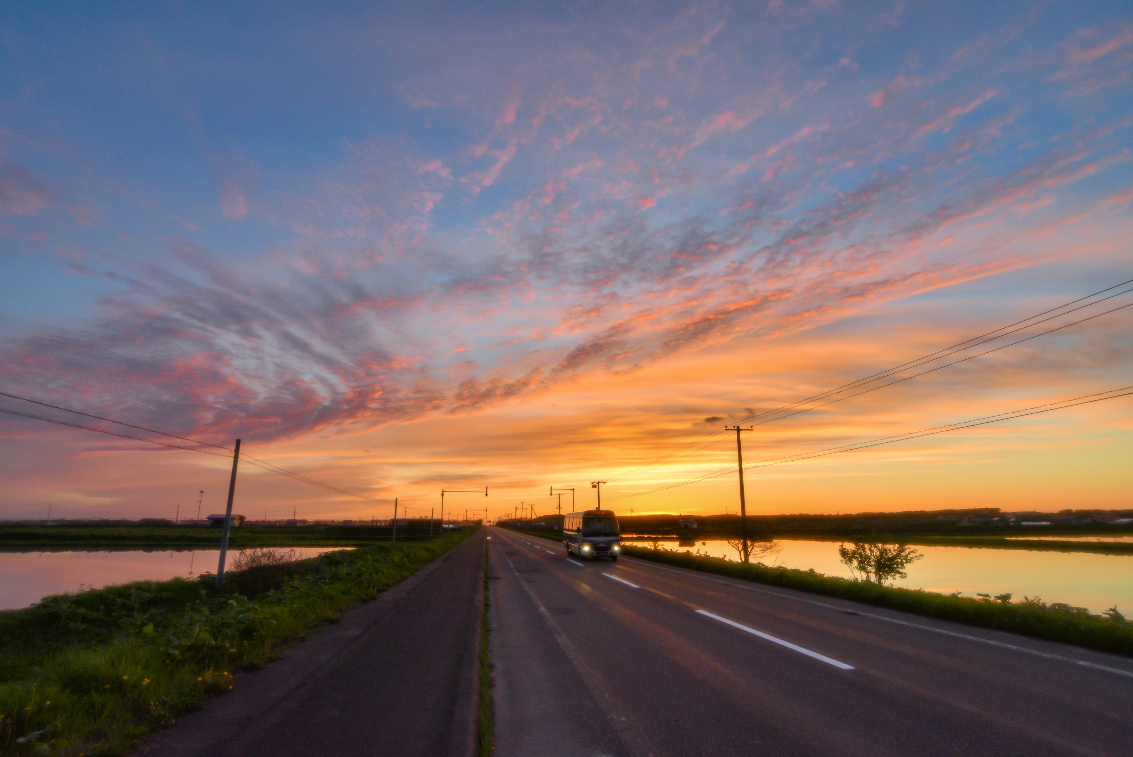 美しい夕焼けの空と道路の風景 車が通り過ぎる