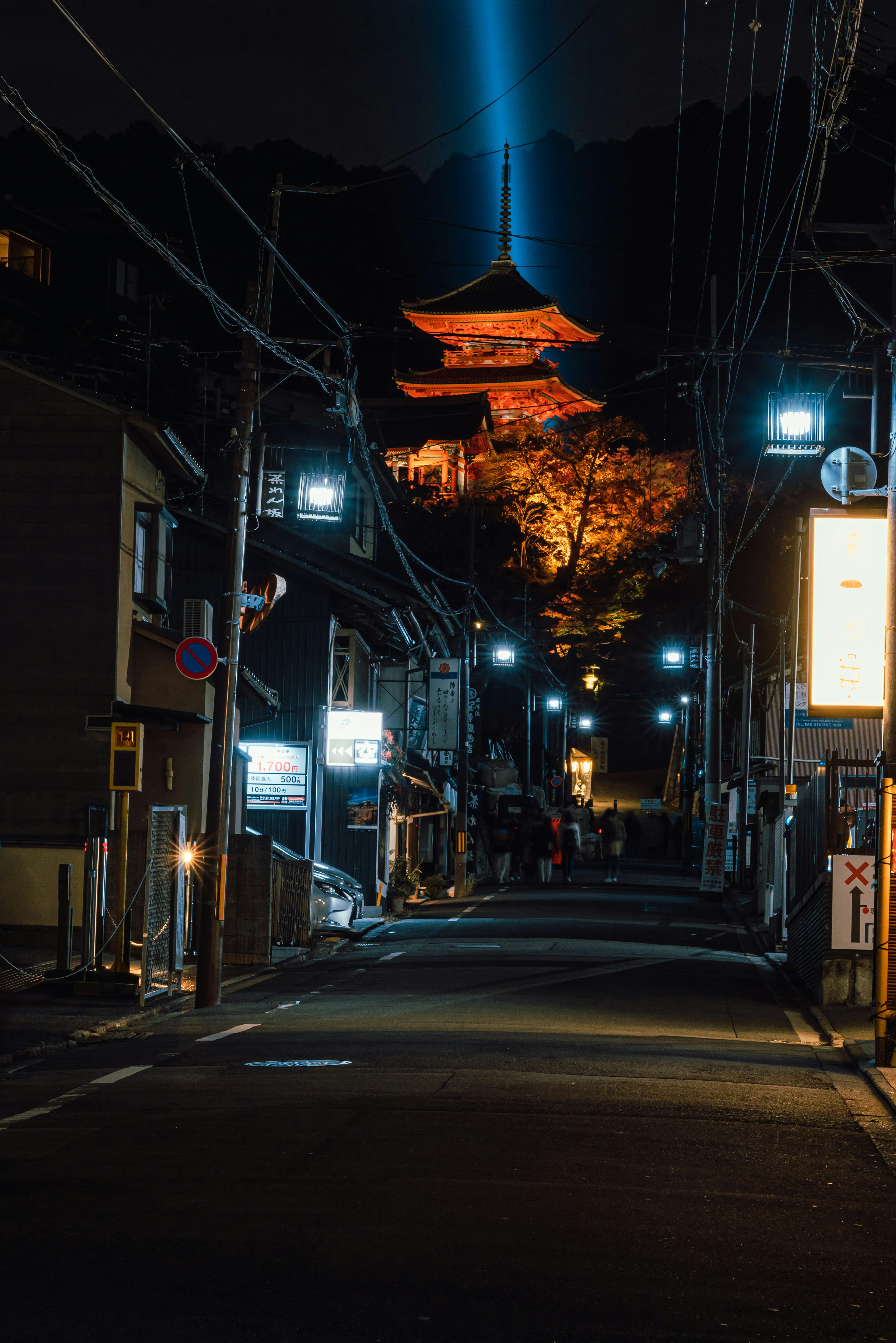 Illuminated temple on a dark street at night