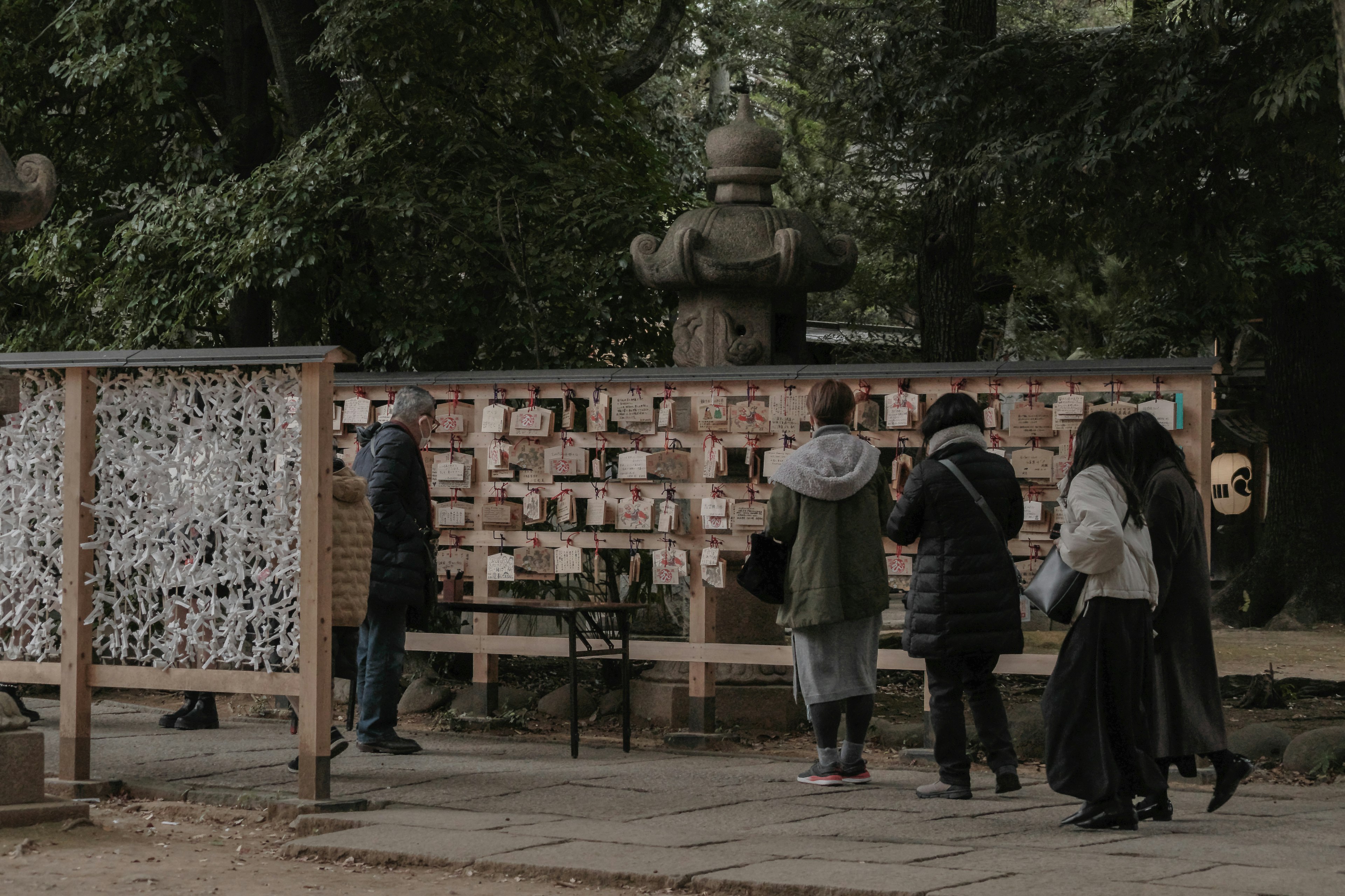 人々が壁に掛けられた木の板を見ている公園の風景