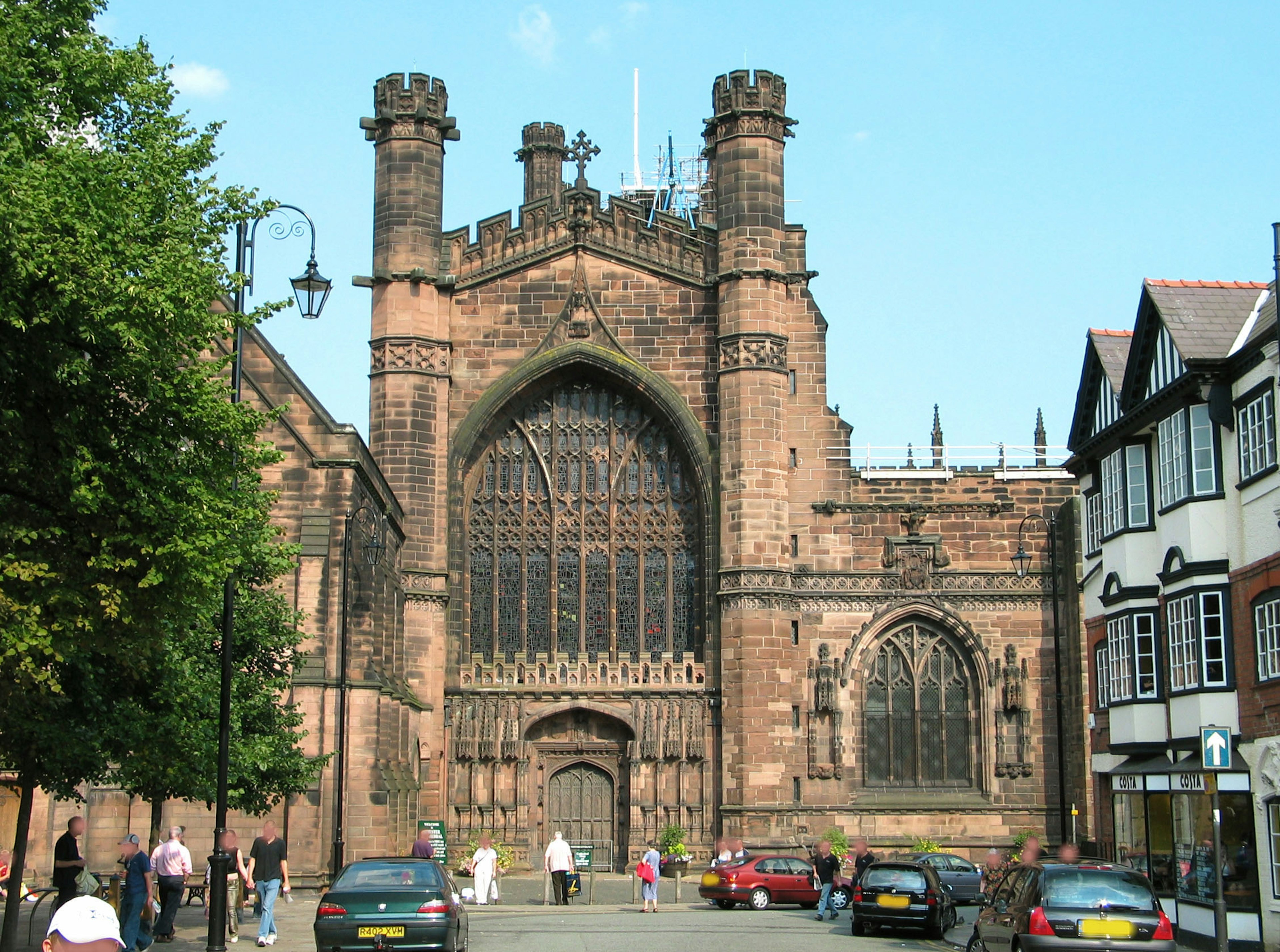 Vista exterior de una iglesia de estilo medieval con personas alrededor