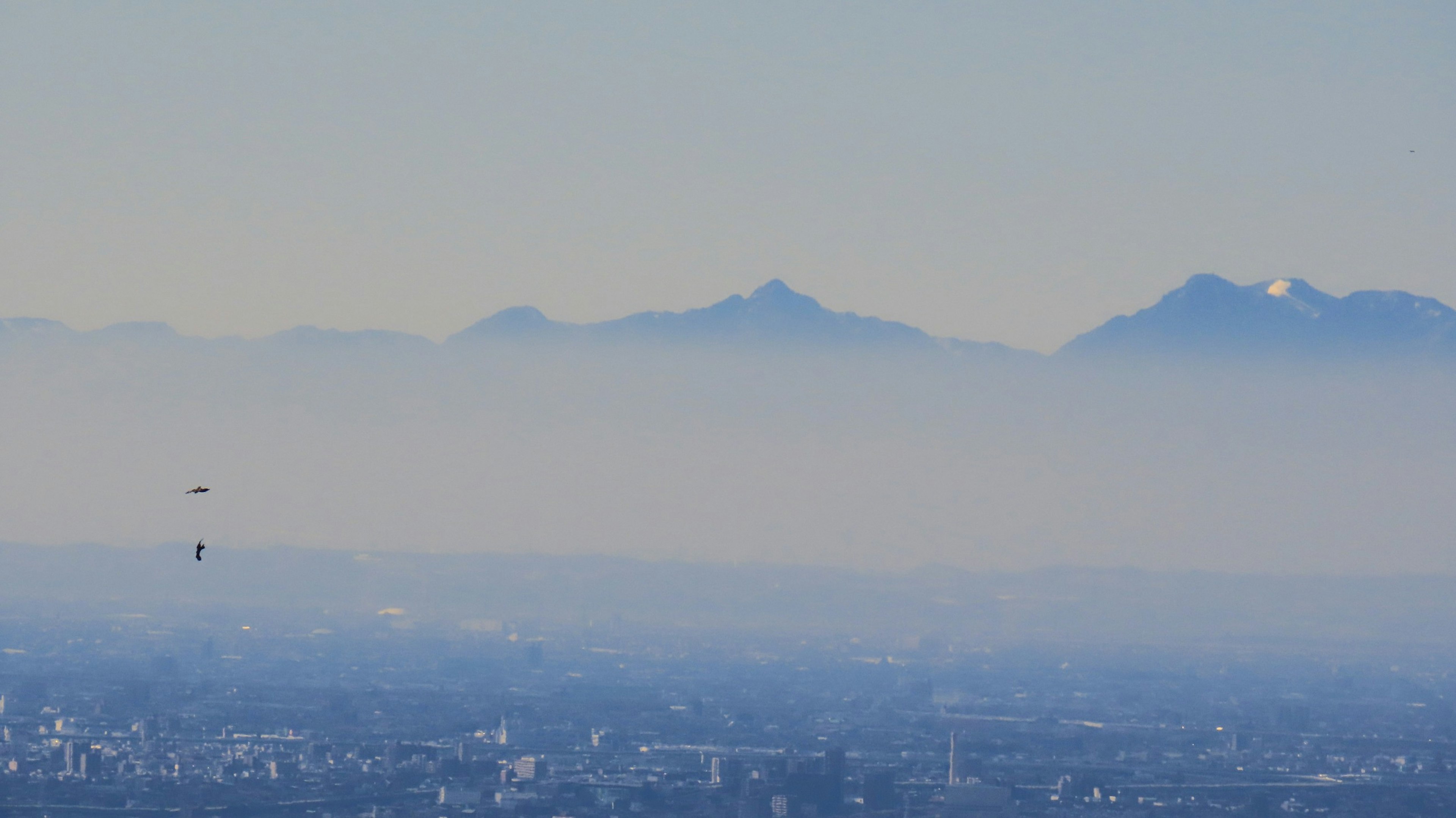 Blick auf blaue Berge in Nebel gehüllt mit einer Stadtlandschaft