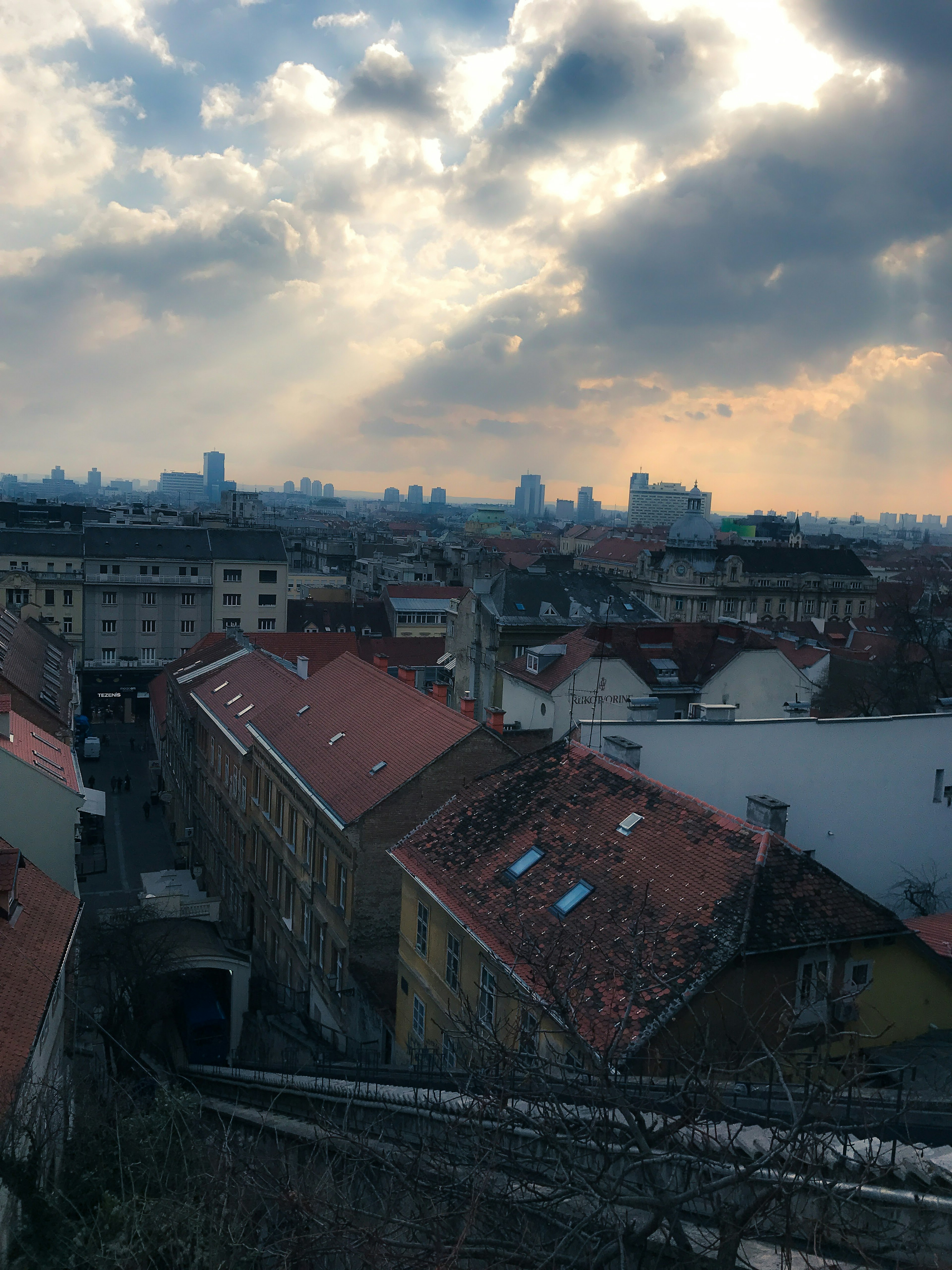 Cityscape with red-roofed houses and cloudy sky