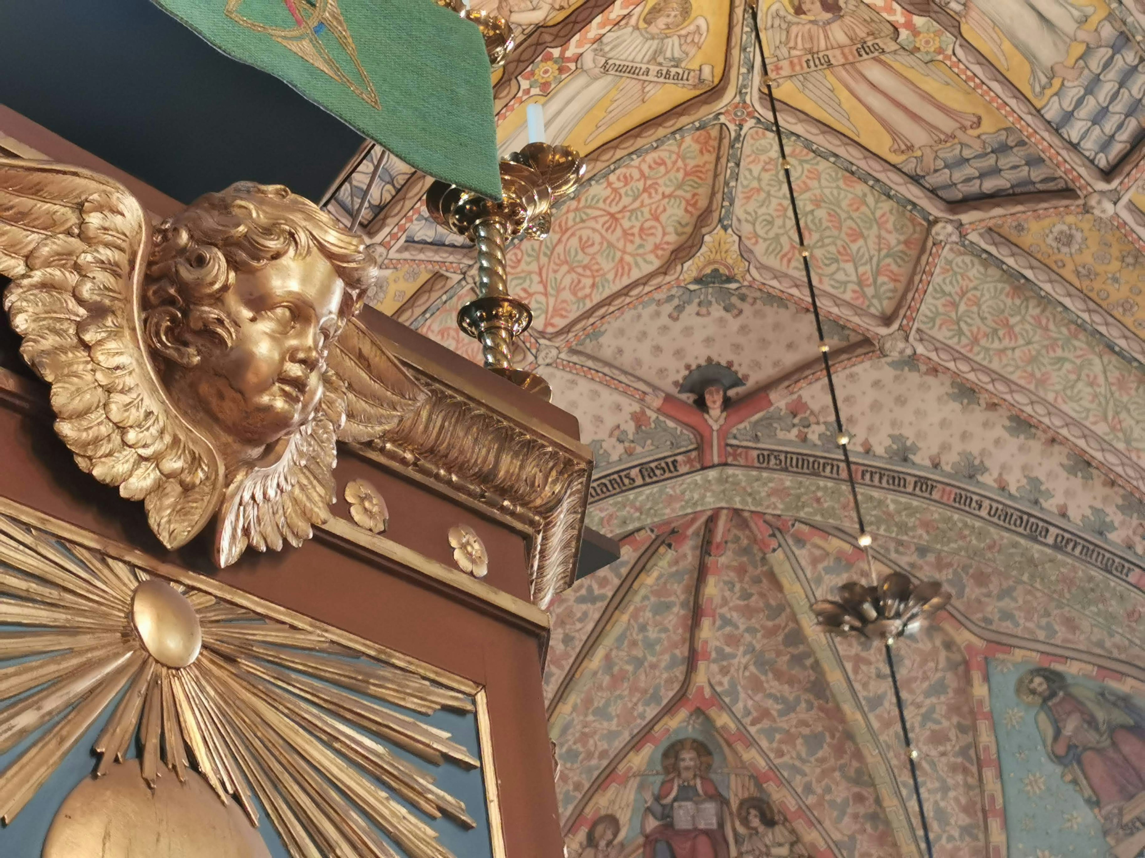 Interior de un edificio histórico con decoraciones doradas y hermosas obras en el techo